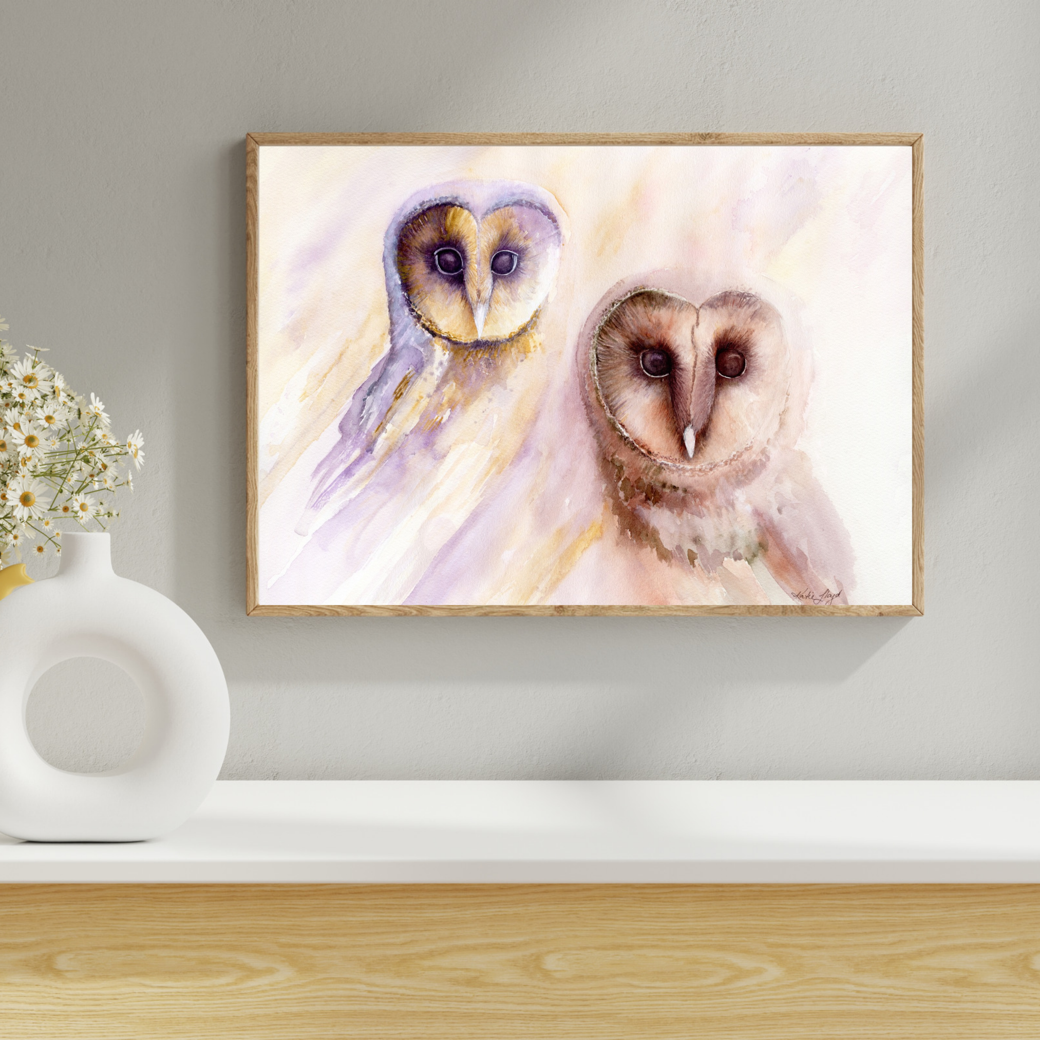 Owl's Wisdom barn owl art print in a natural oak frame on a soft grey wall above a timber shelf with a white vase