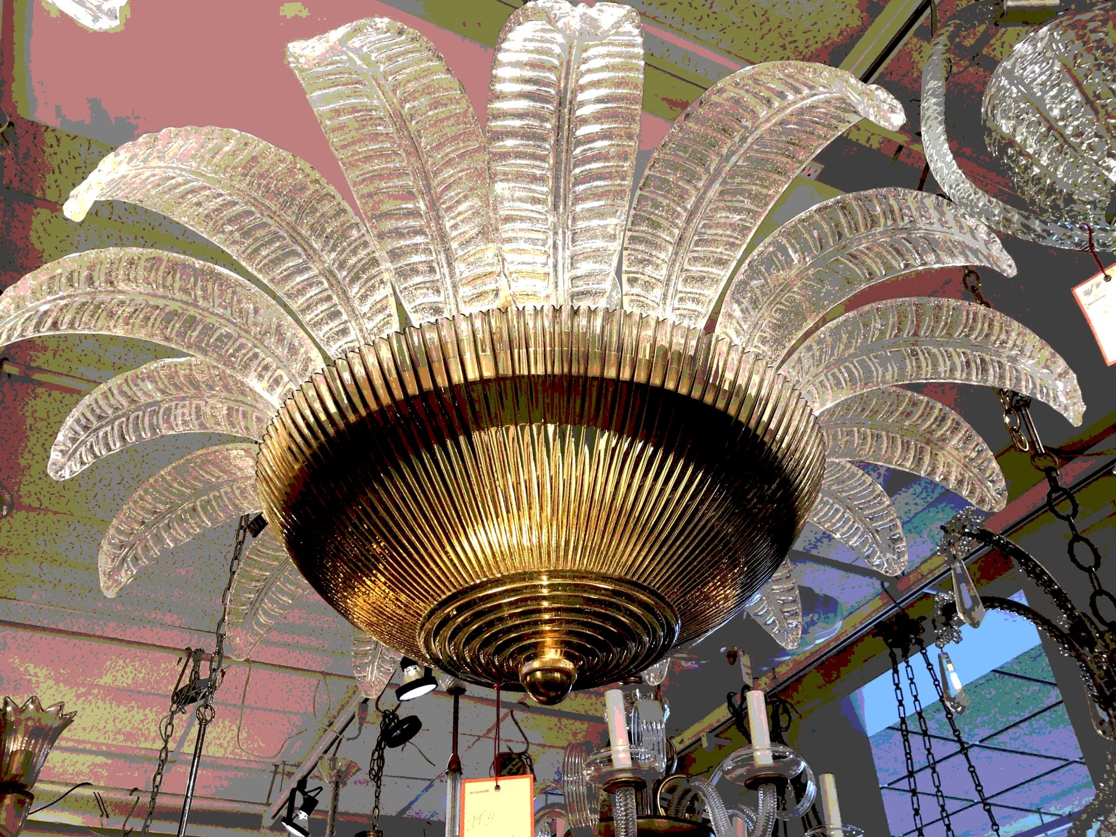 A decorative chandelier with multiple leaves and hanging chains, featured in a lighting store.