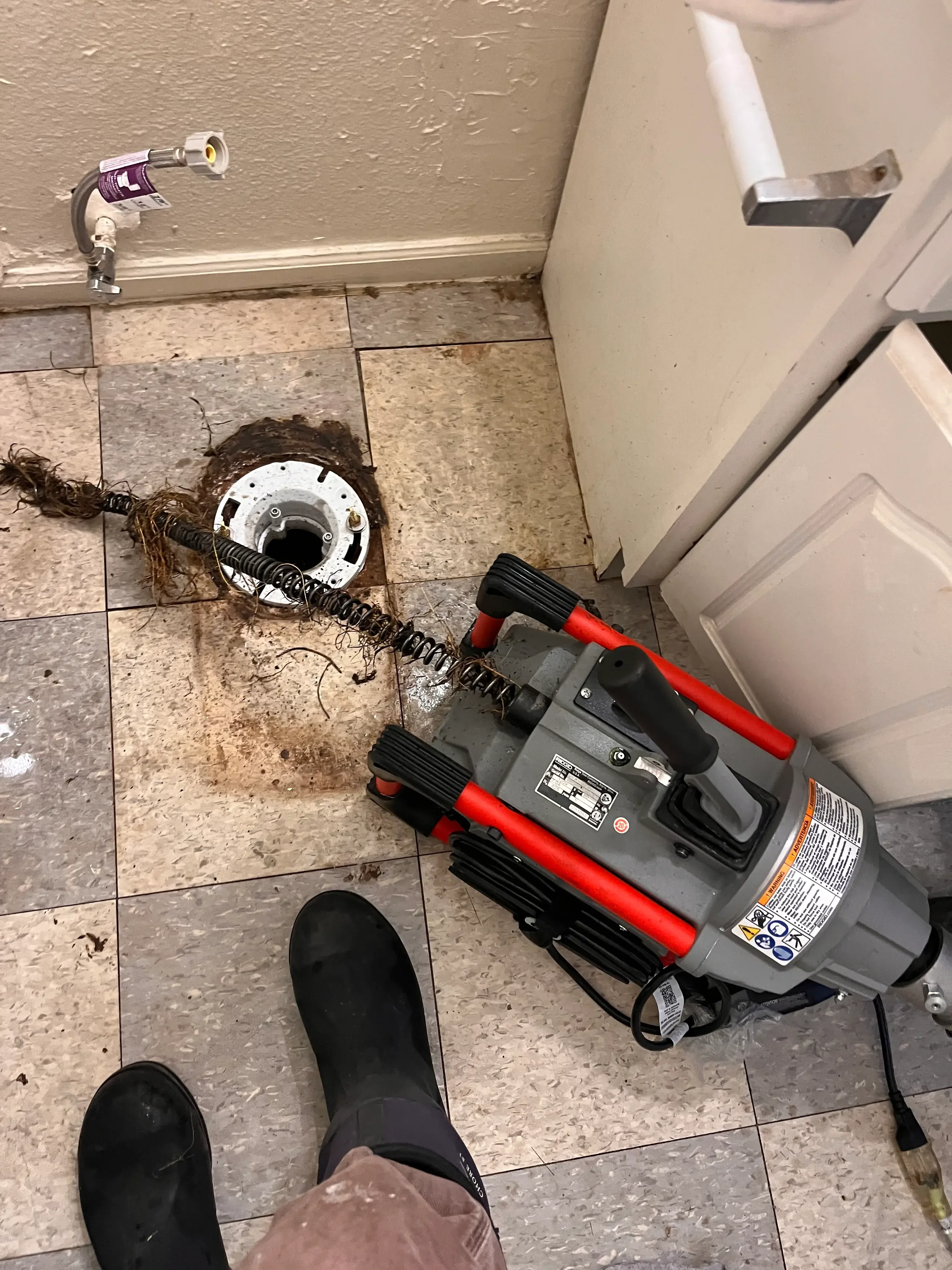technician performing drain cleaning in Topeka and drain cleaning tree roots to unclog drain