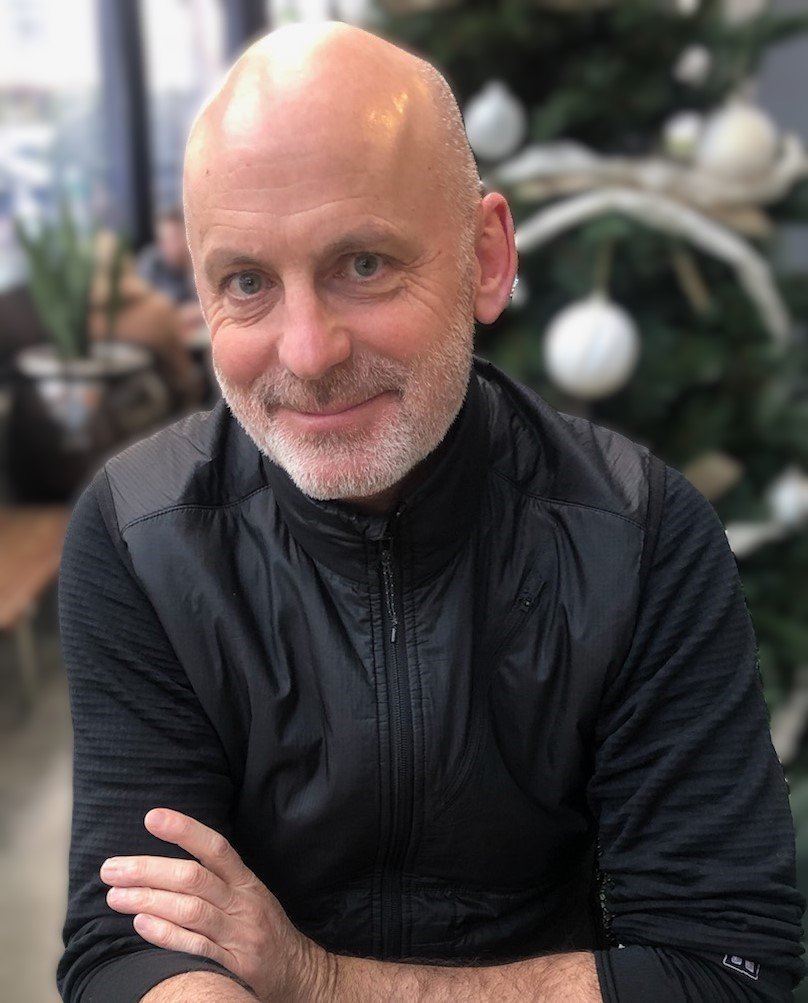 Middle-aged man in black jacket, welcoming and approachable, symbolizing client-centred counselling and mental health support.