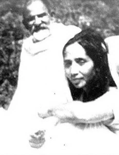 A black-and-white photo of a man with a beard and a woman, sitting together outdoors.