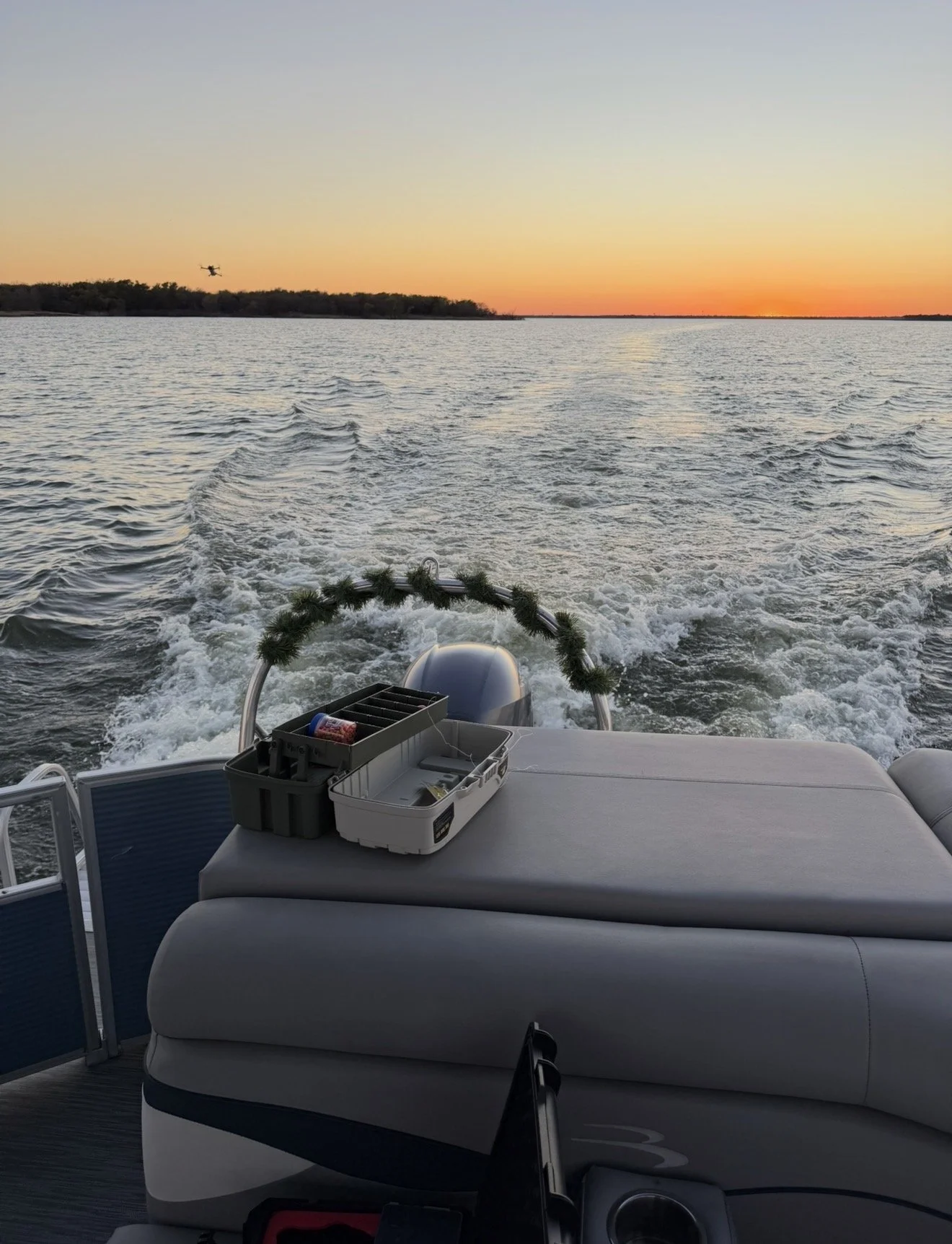 BoatByVal pontoon boat cruising near Little Elm during sunset on Lake Lewisville