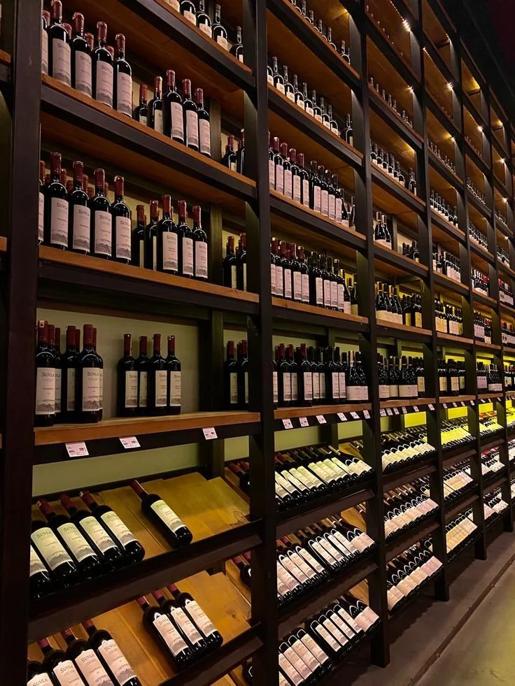 Wine bottles on wooden shelves in a wine shop.
