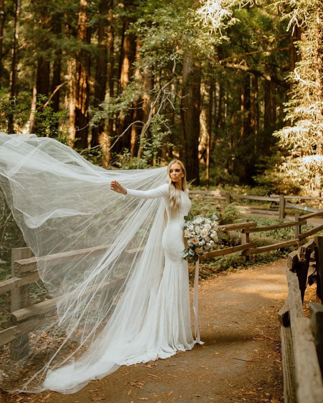 A bride shown outdoors wearing an elegant gown