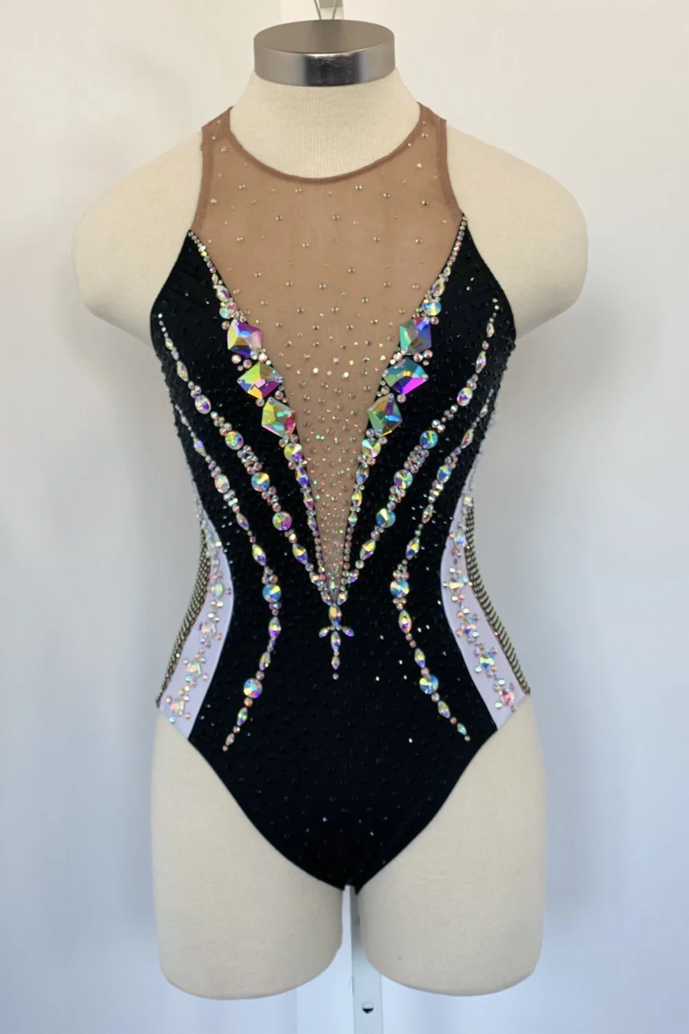 An aerial costume shown on a mannequin with detail of attached crystals shown