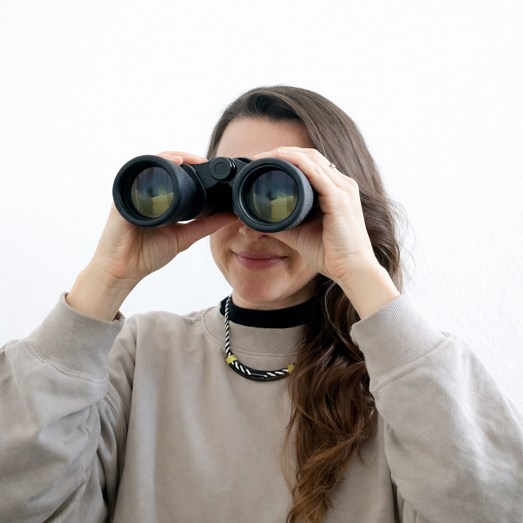 Baubiologin mit Fernglas als Symbol für Analyse und Planung – nachhaltige Architektur, wohngesundes Bauen, schadstofffreie Materialien und ökologische Innenraumgestaltung