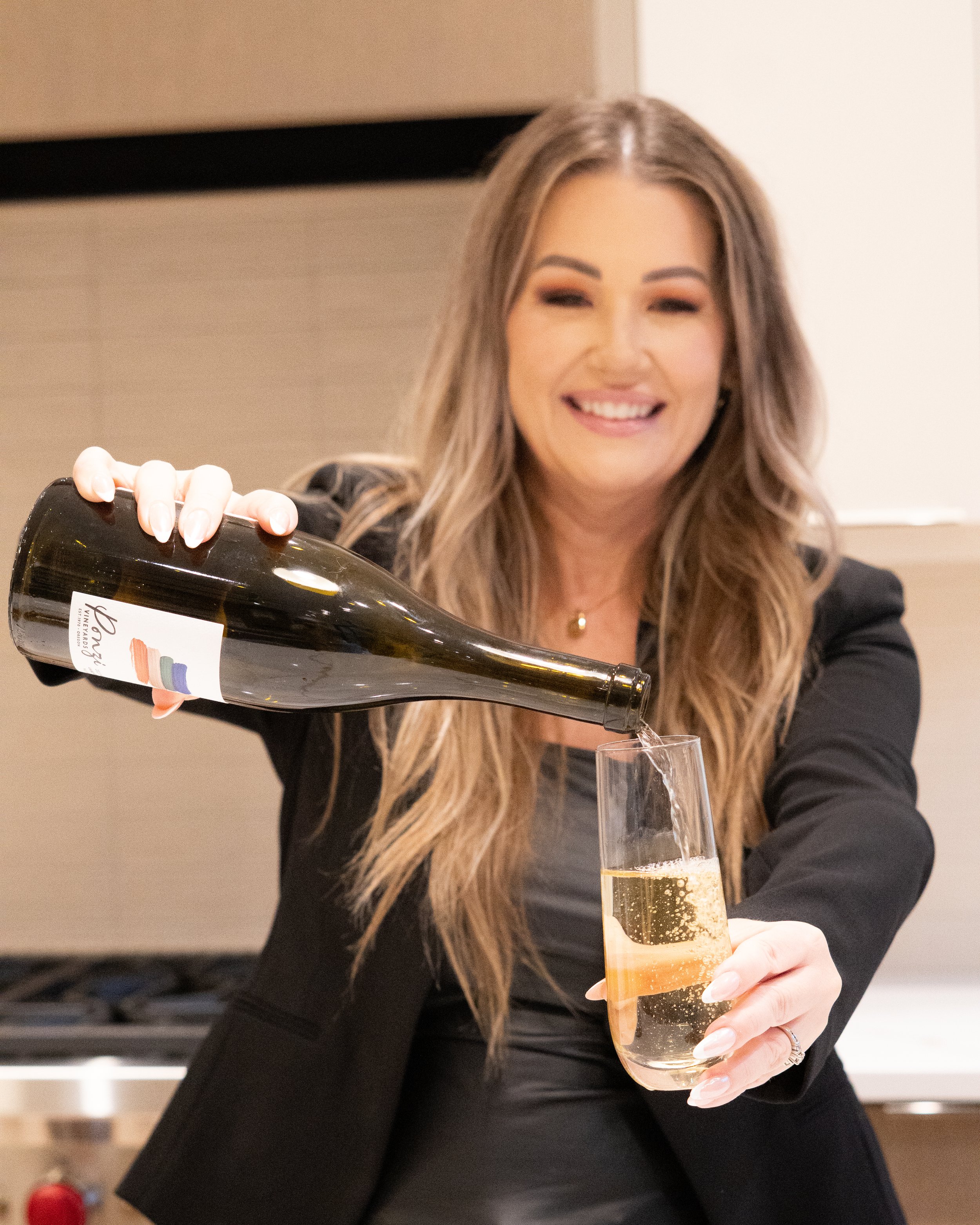 Jill Saucedo, Portland metro real estate agent, pouring champagne