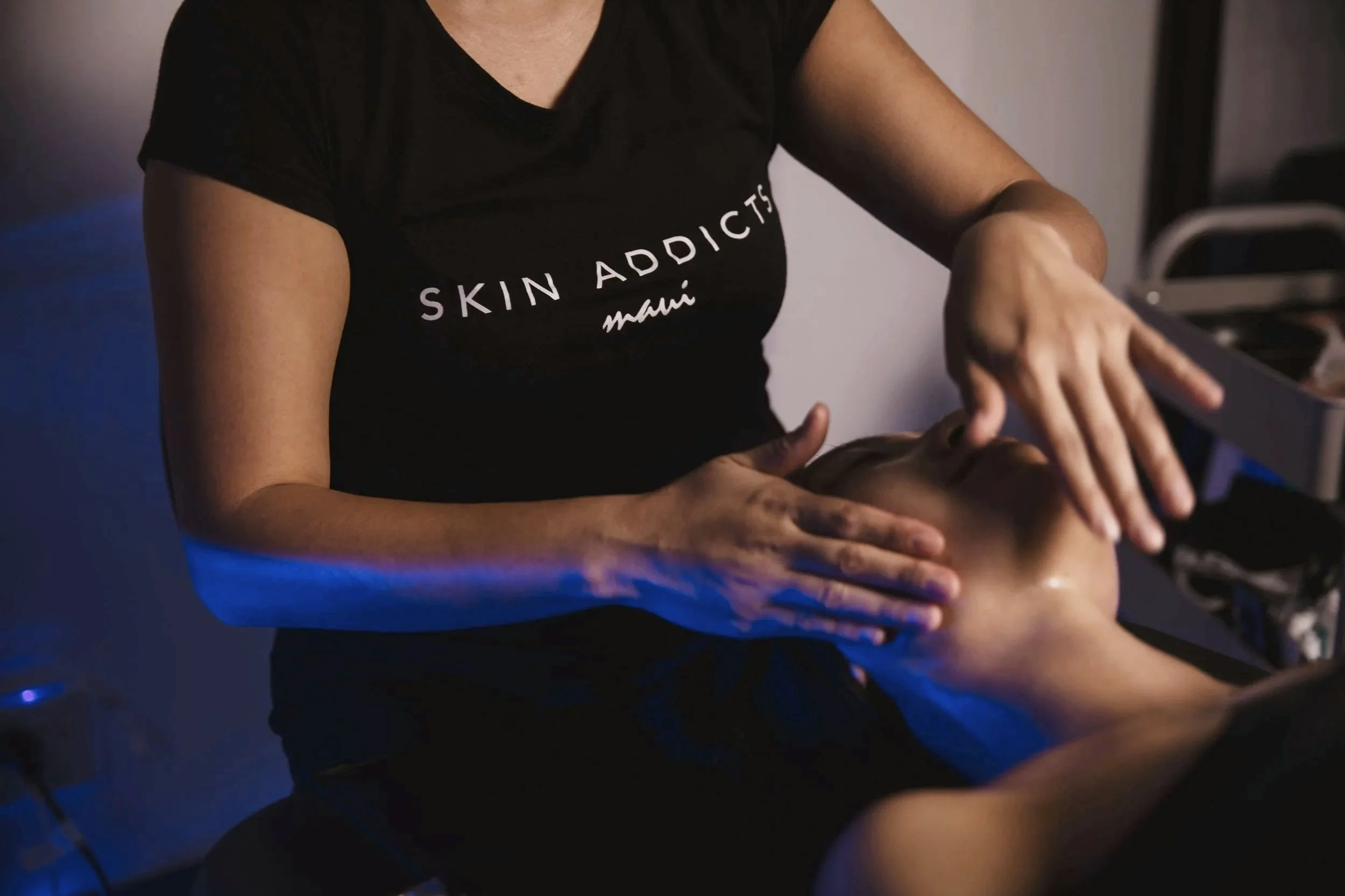 A woman receiving a facial massage at a spa or skincare clinic.