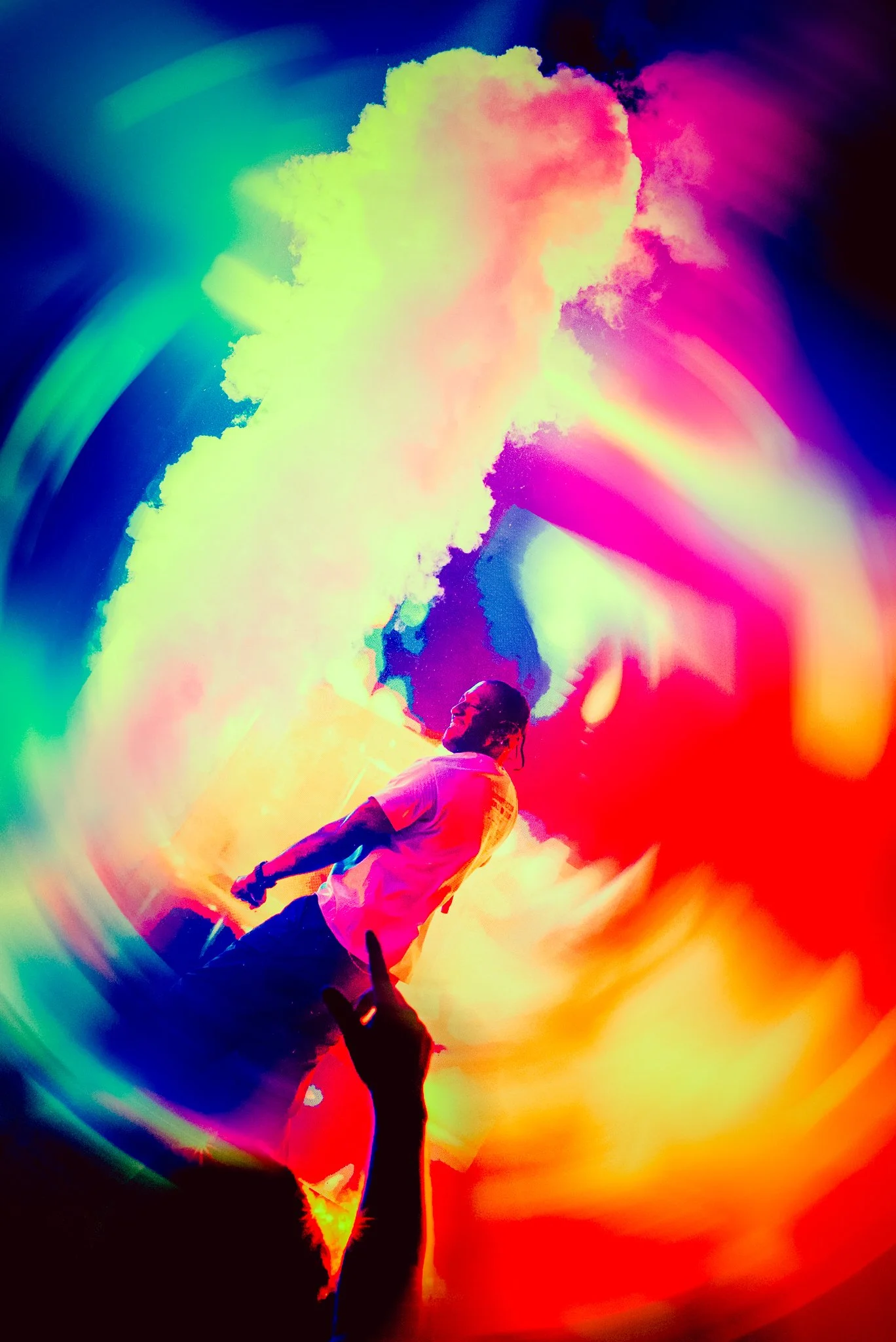 A person with braided hair singing on stage with colorful smoke and lights in the background.