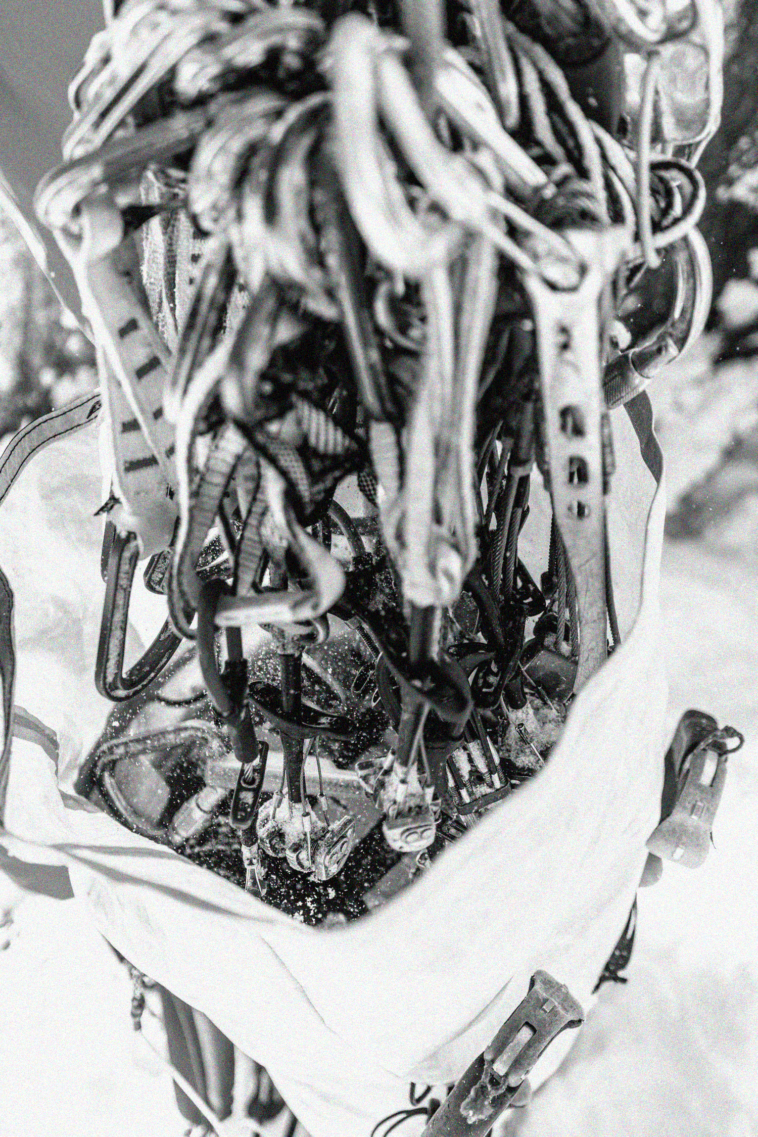 Un sac contenant des vêtements et des objets divers, posé dans la neige, vu de dessus.