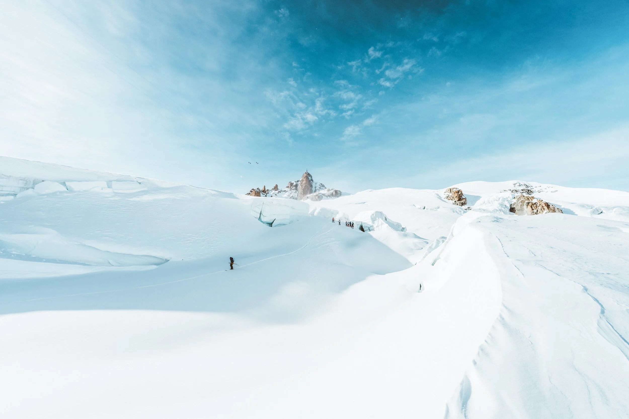 Paysage glacé avec des skieurs et un ciel bleu clair.