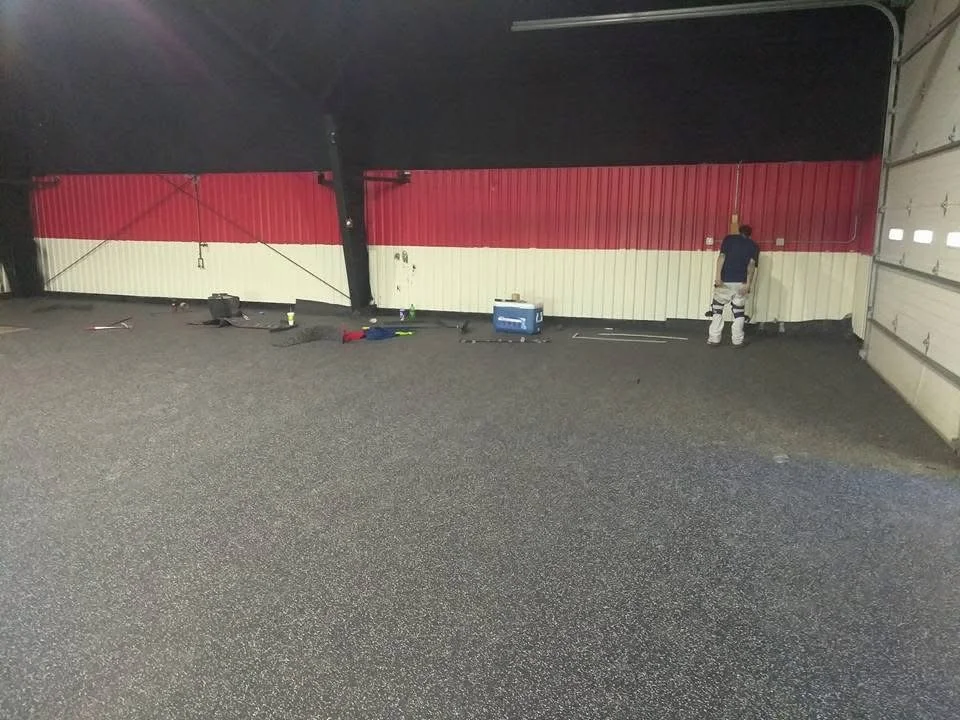 Rubber gym flooring installed with a smooth, even surface ideal for weightlifting and cardio equipment.