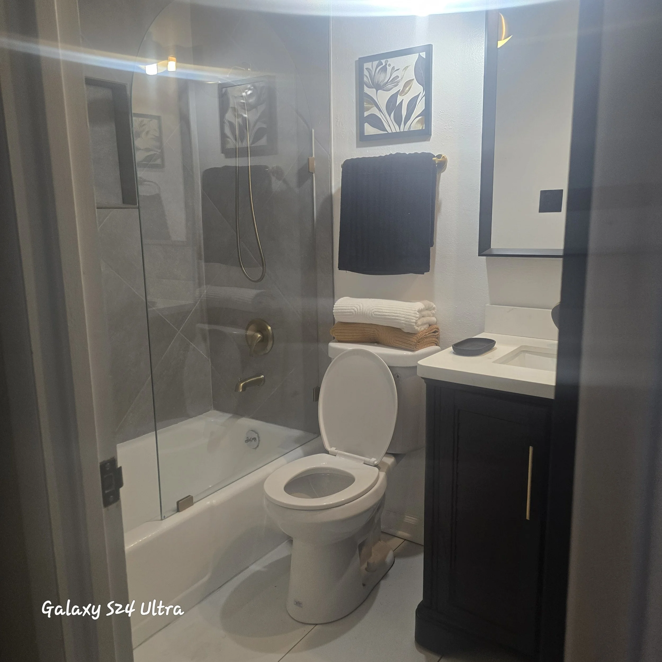 St Louis Bathroom complete remodel with tile shower walls, tile flooring, shower doors installed, and vanity and mirror installed. 