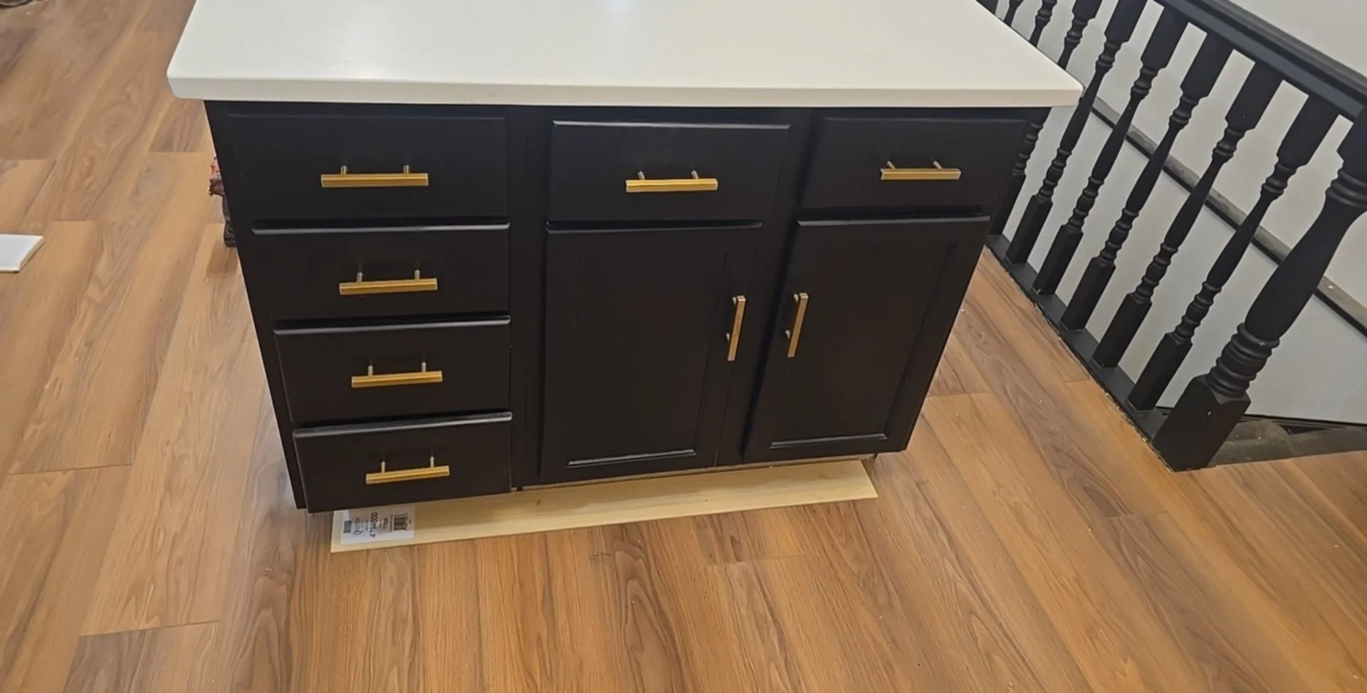 Laminate flooring in a St. Louis kitchen with precision cuts around island and staircase.
