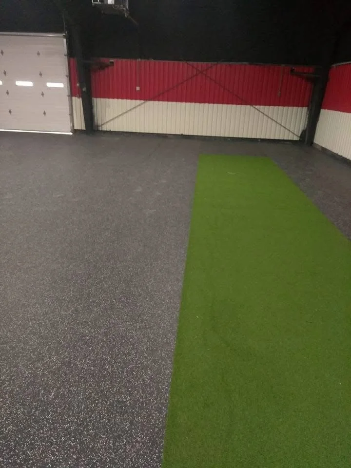 Seamless rubber flooring paired with indoor turf to create a functional workout and agility area.