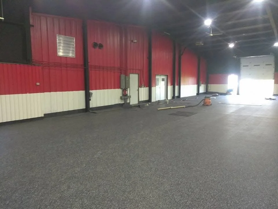 Rubber flooring installed in a gym area with clean edges and a smooth, even surface. 
