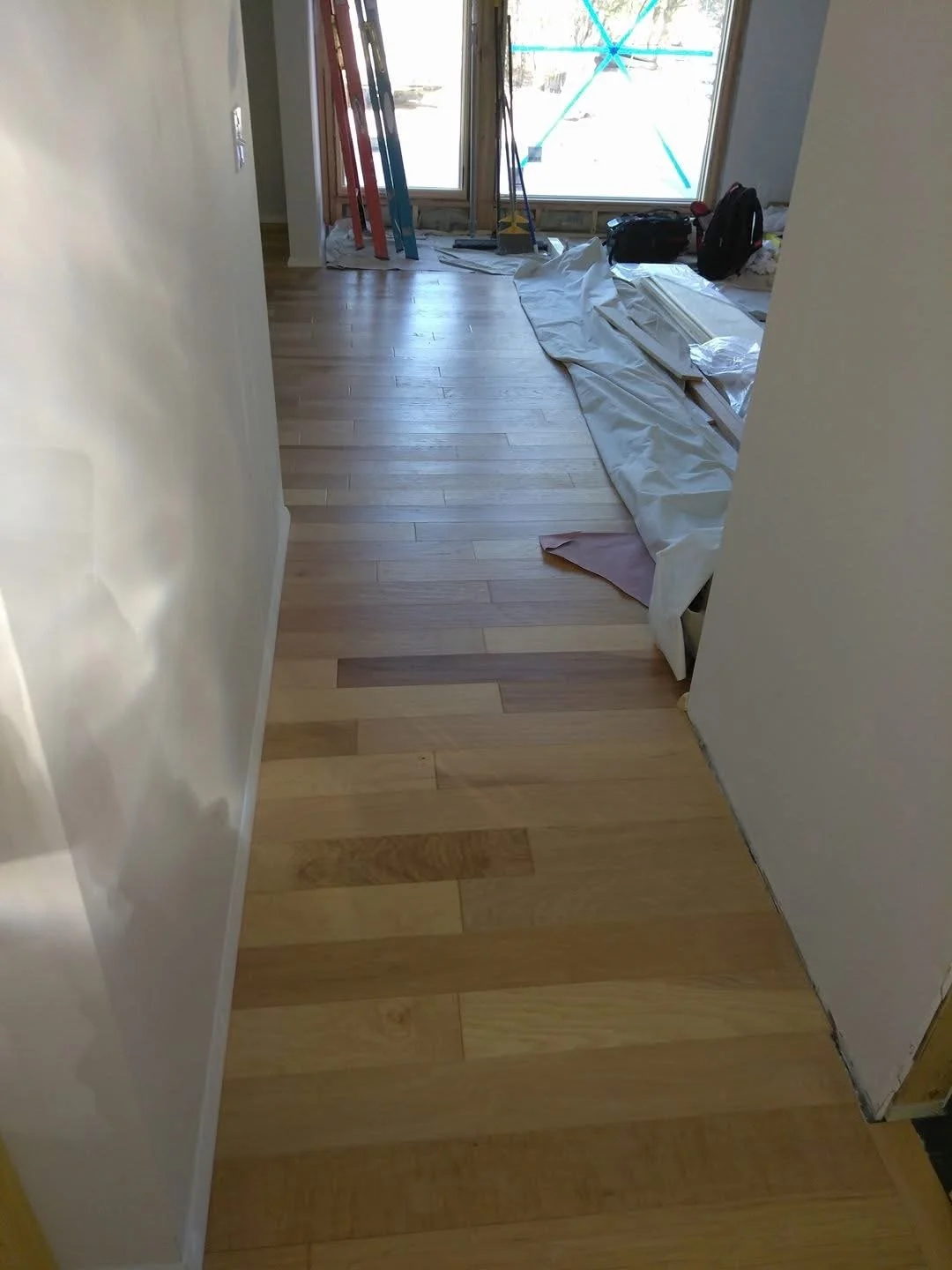 Hardwood flooring installed in a hallway with tight seams and a uniform layout. 