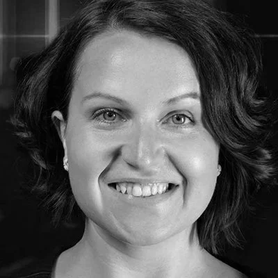 Nahaufnahme eines lächelnden Frauenporträts in Schwarzweiß.