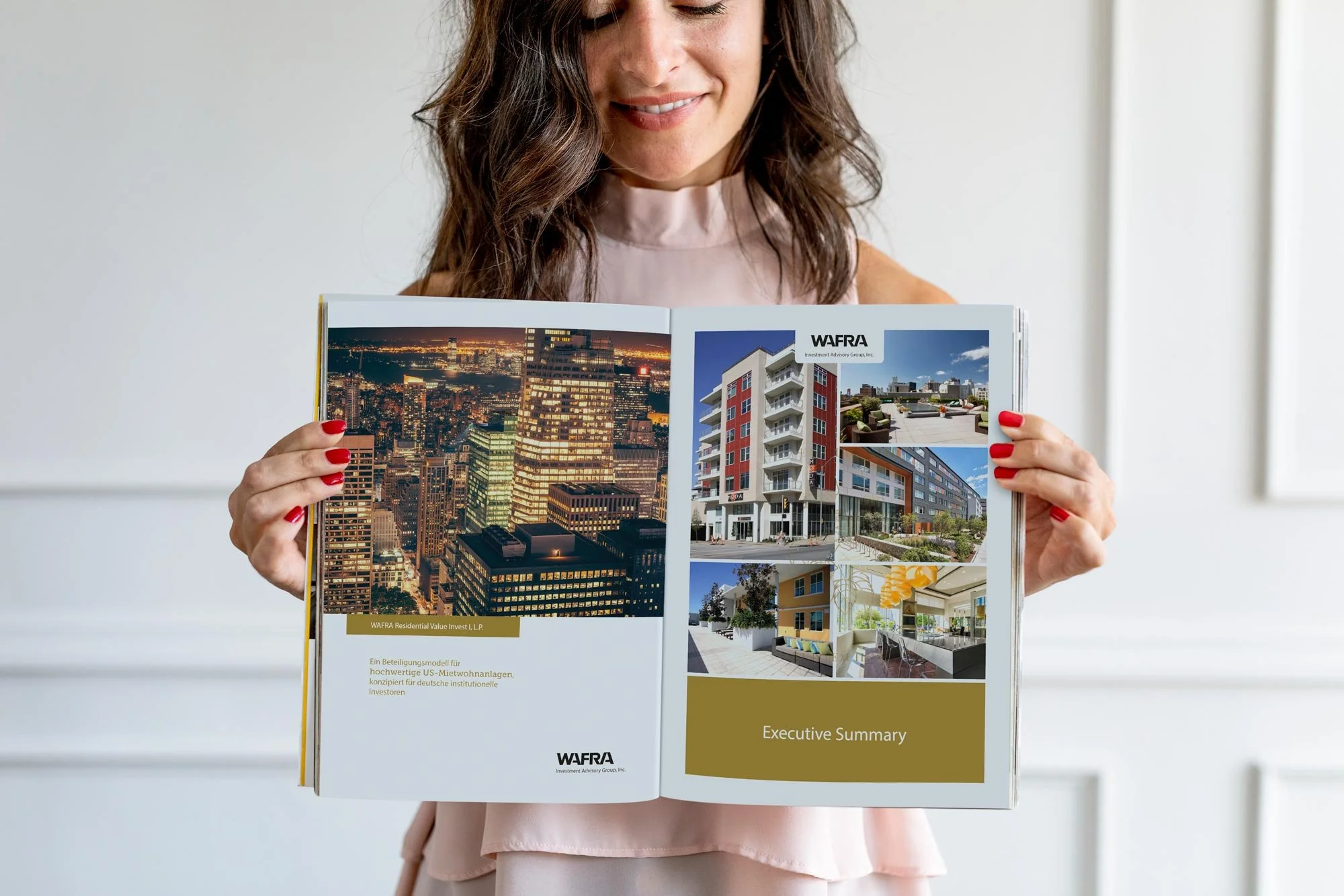 Frau hält auf einer weißen Wand im Hintergrund eine Broschüre mit Fotos von Stadt- und Wohngebäuden, Titel "Executive Summary" auf der rechten Seite, und Texte in Deutsch auf der linken Seite.