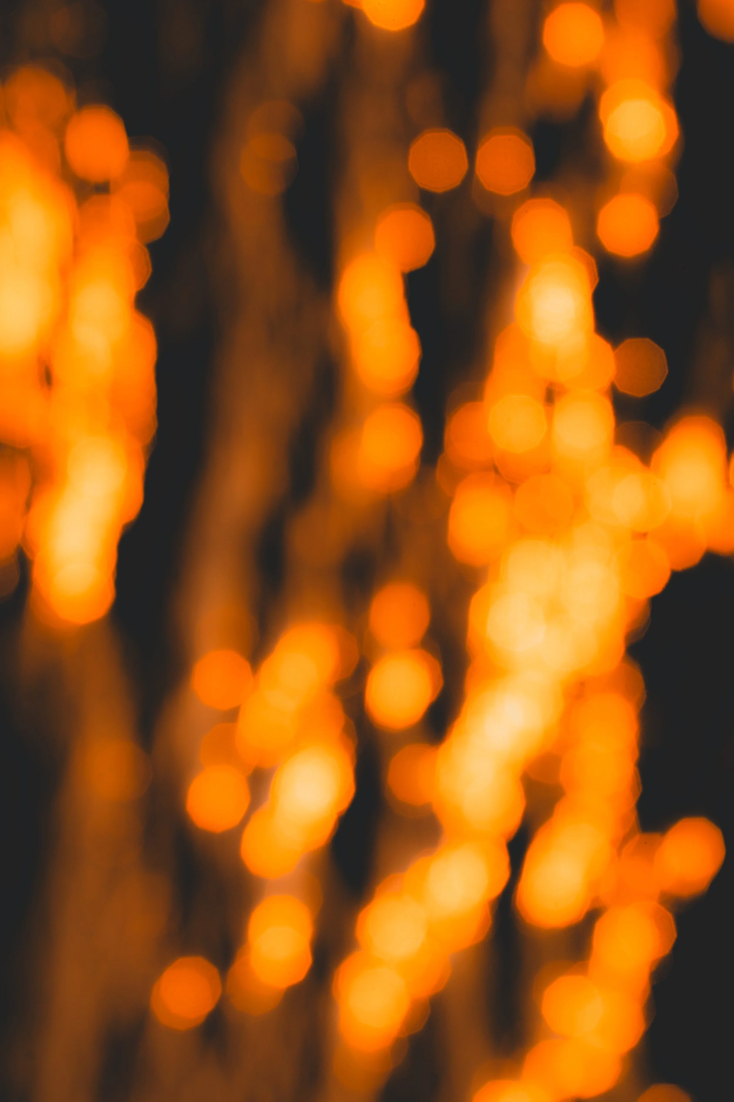 Fête de lumières avec des guirlandes lumineuses orange floues en arrière-plan.