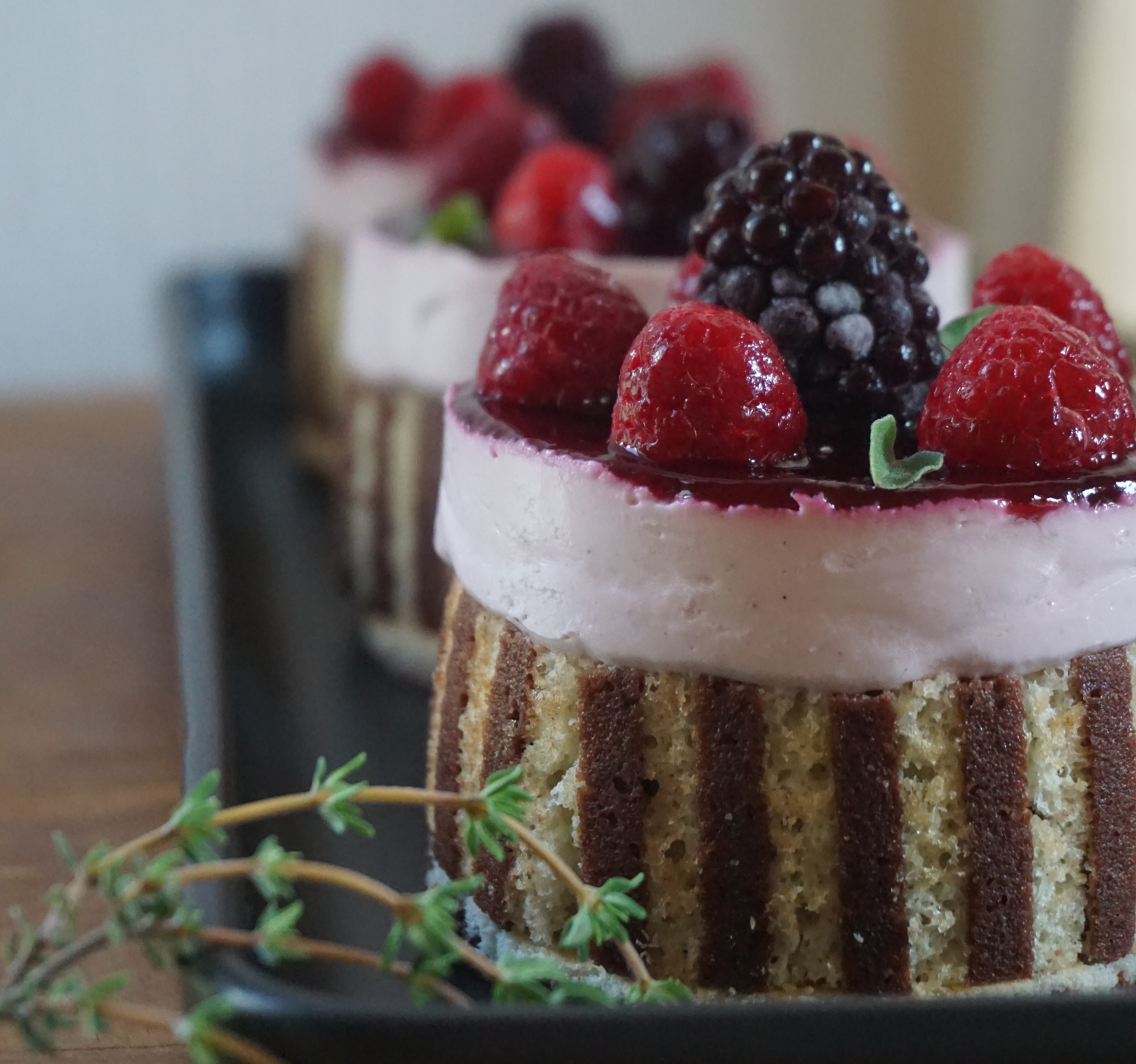 Törtchen mit Dekorbiskuit mit Beeren und grün geschmückt