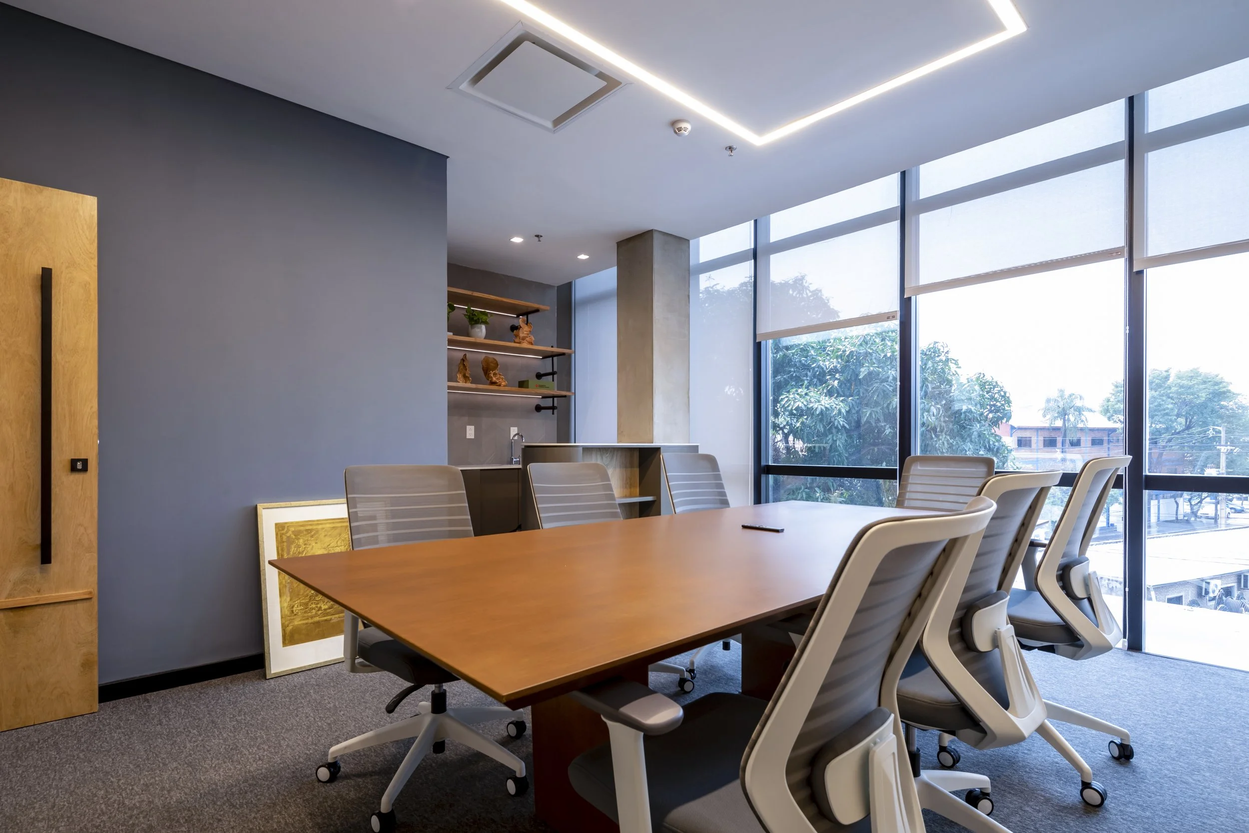 PRO ARQUITECTURA PARAGUAY architecture design PROSA
Sala de reuniones con mesa de madera y sillas ergonómicas junto a ventanas grandes que dejan pasar luz natural.