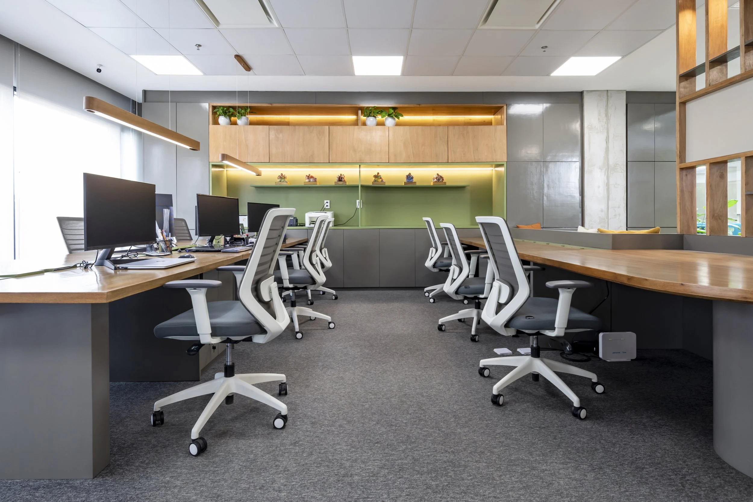 PRO ARQUITECTURA PARAGUAY architecture design PROSA
oficina moderna con escritorios de madera y sillas ergonómicas blancas, ordenadores y plantas decorativas en estantes.