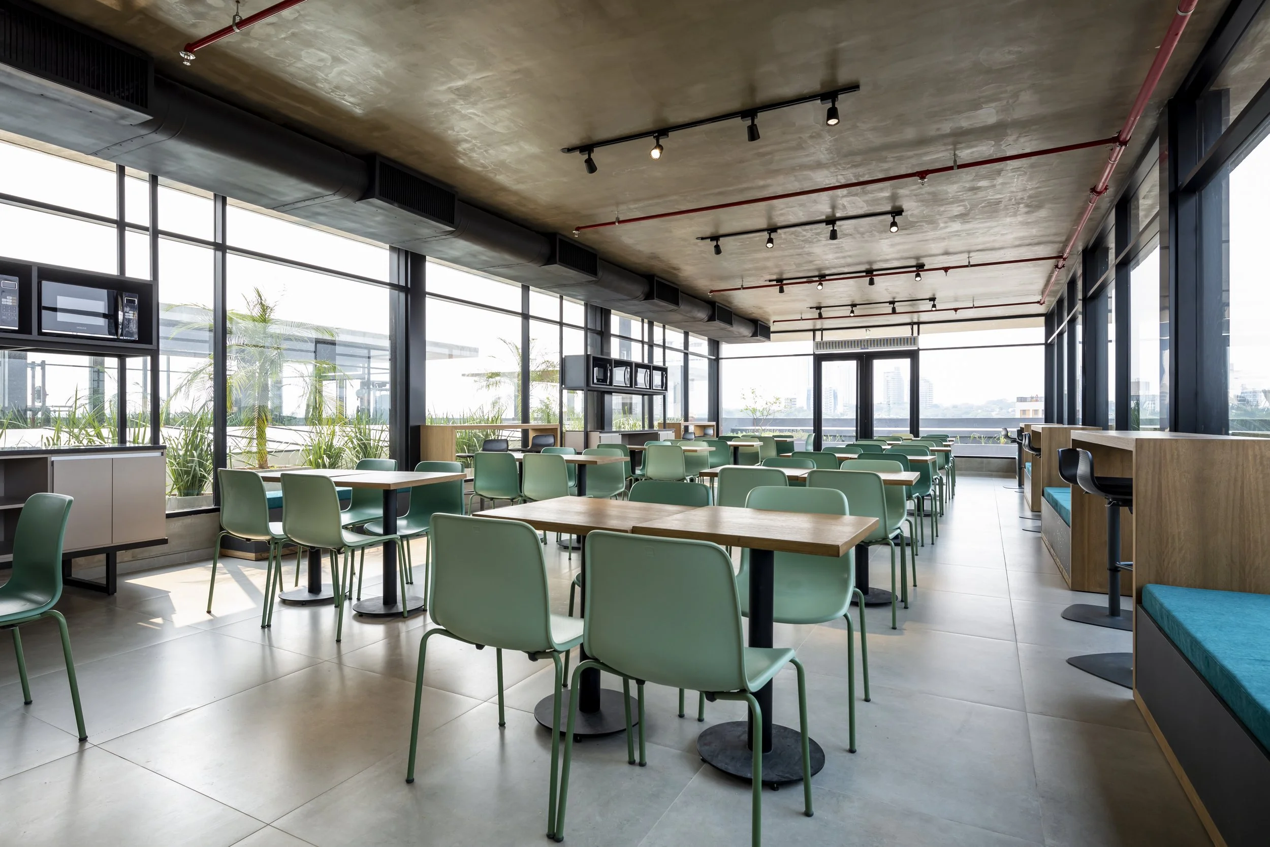 PRO ARQUITECTURA PARAGUAY architecture design PROSA
Interior de un restaurante moderno con muchas mesas y sillas verdes, ventanas grandes y vista al exterior, con iluminación artificial en el techo.