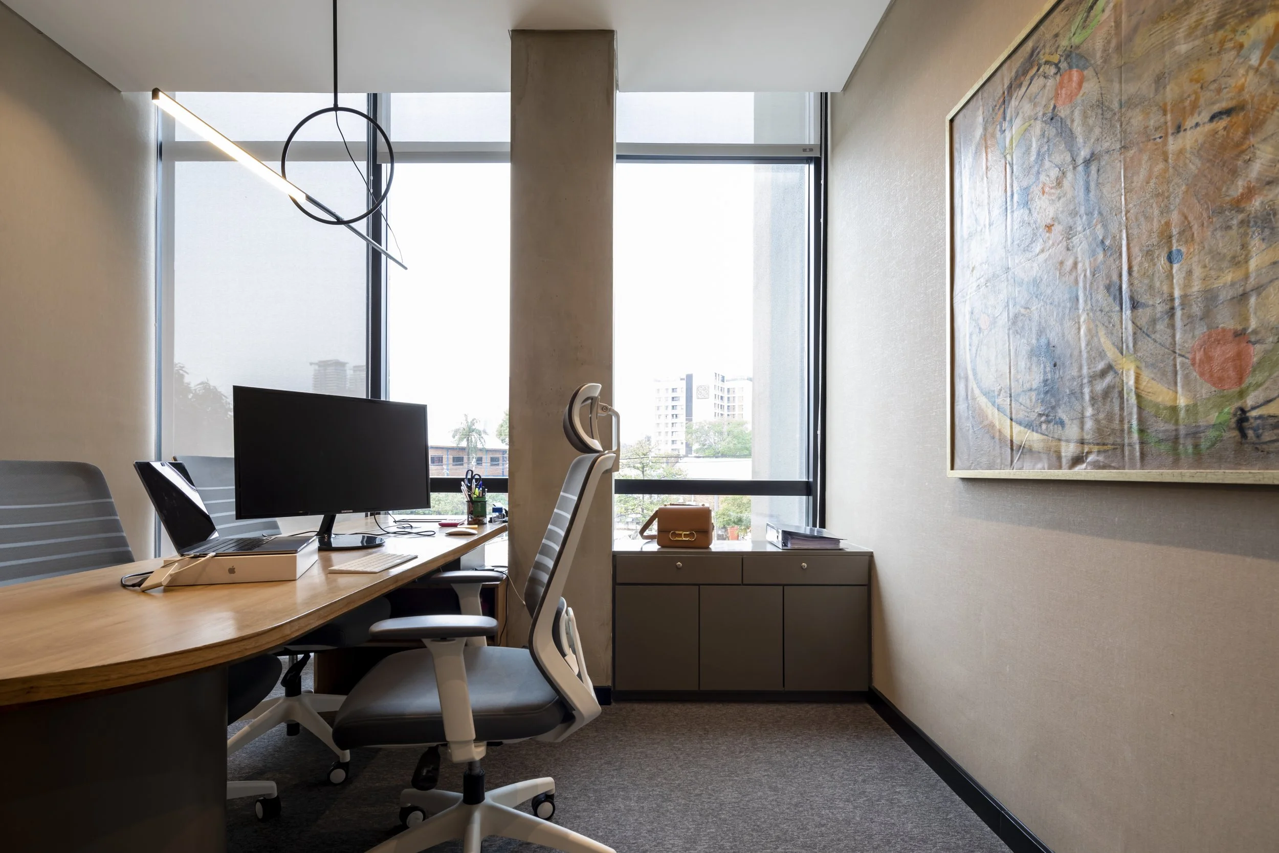 PRO ARQUITECTURA PARAGUAY architecture design PROSA
Oficina moderna con mesa, monitor, silla y vista a edificios y árboles