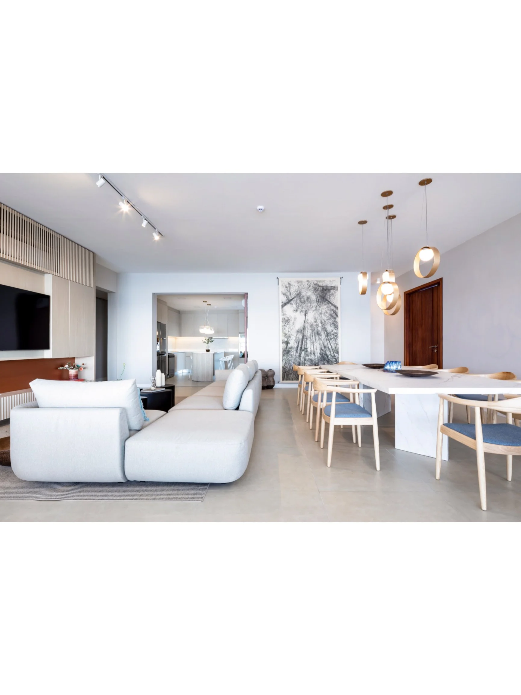 PRO ARQUITECTURA PARAGUAY architecture design PROSA
Sala de estar moderna y amplia con sillón beige, televisión y comedor con sillas de madera y cojines oscuros, decorada con arte en la pared y lámparas colgantes.