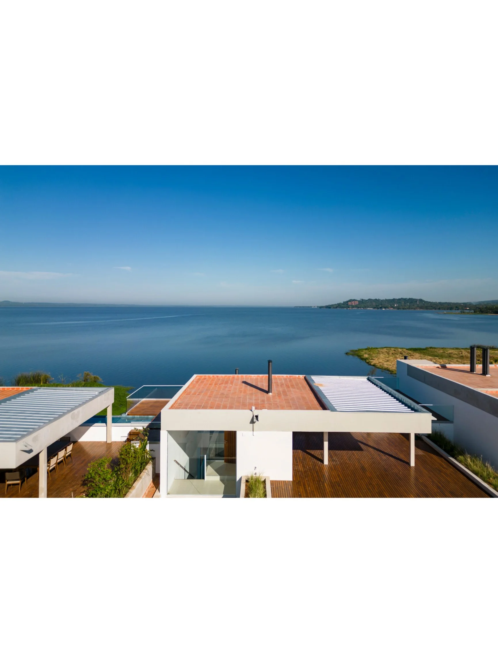 PRO ARQUITECTURA PARAGUAY architecture design PROSA
Vistas aéreas de casas modernas junto a un lago con cielo despejado.