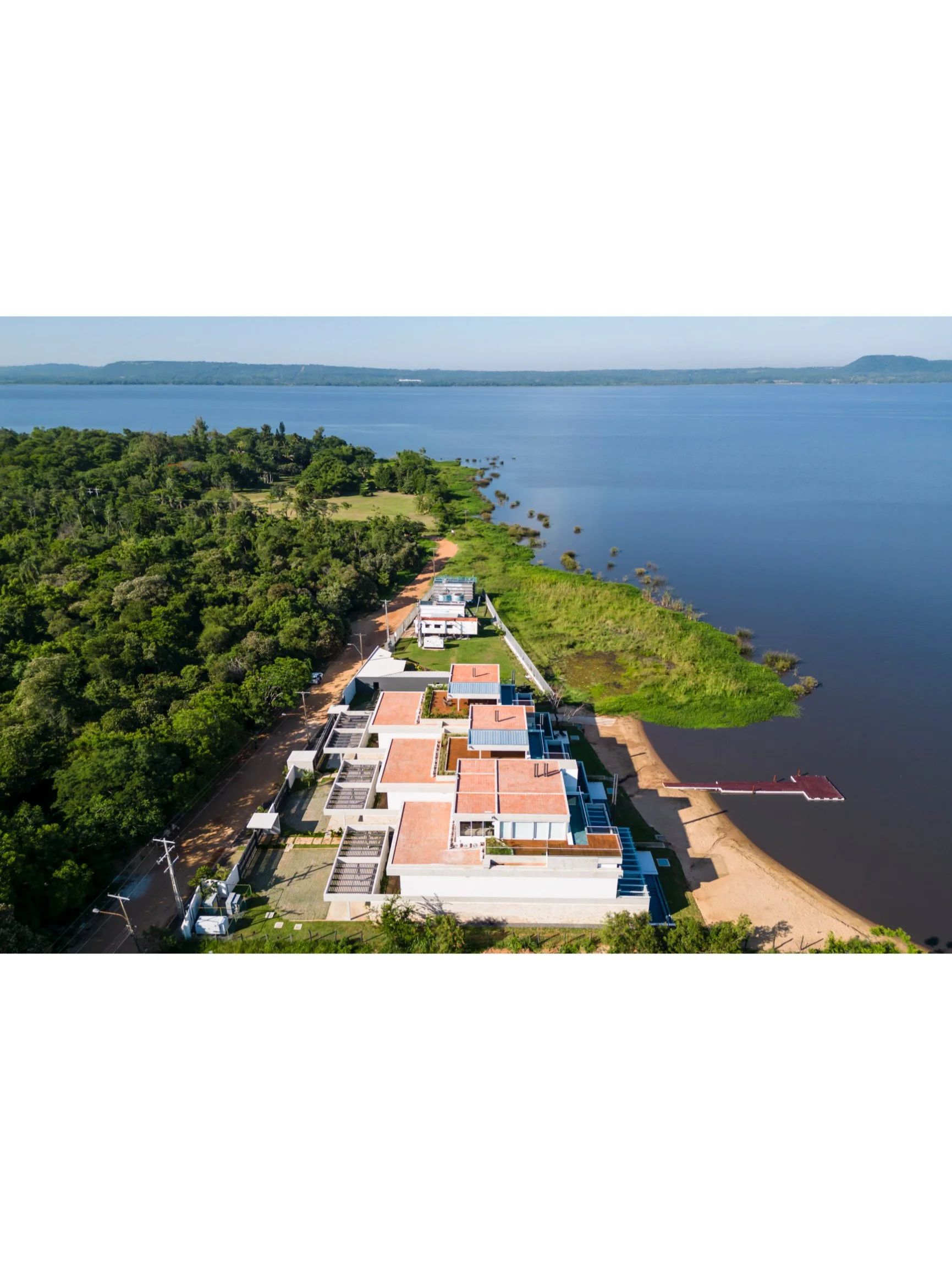 PRO ARQUITECTURA PARAGUAY architecture design PROSA
Conjunto de casas modernas junto a un río, rodeadas de vegetación y con un muelle en la orilla del agua.