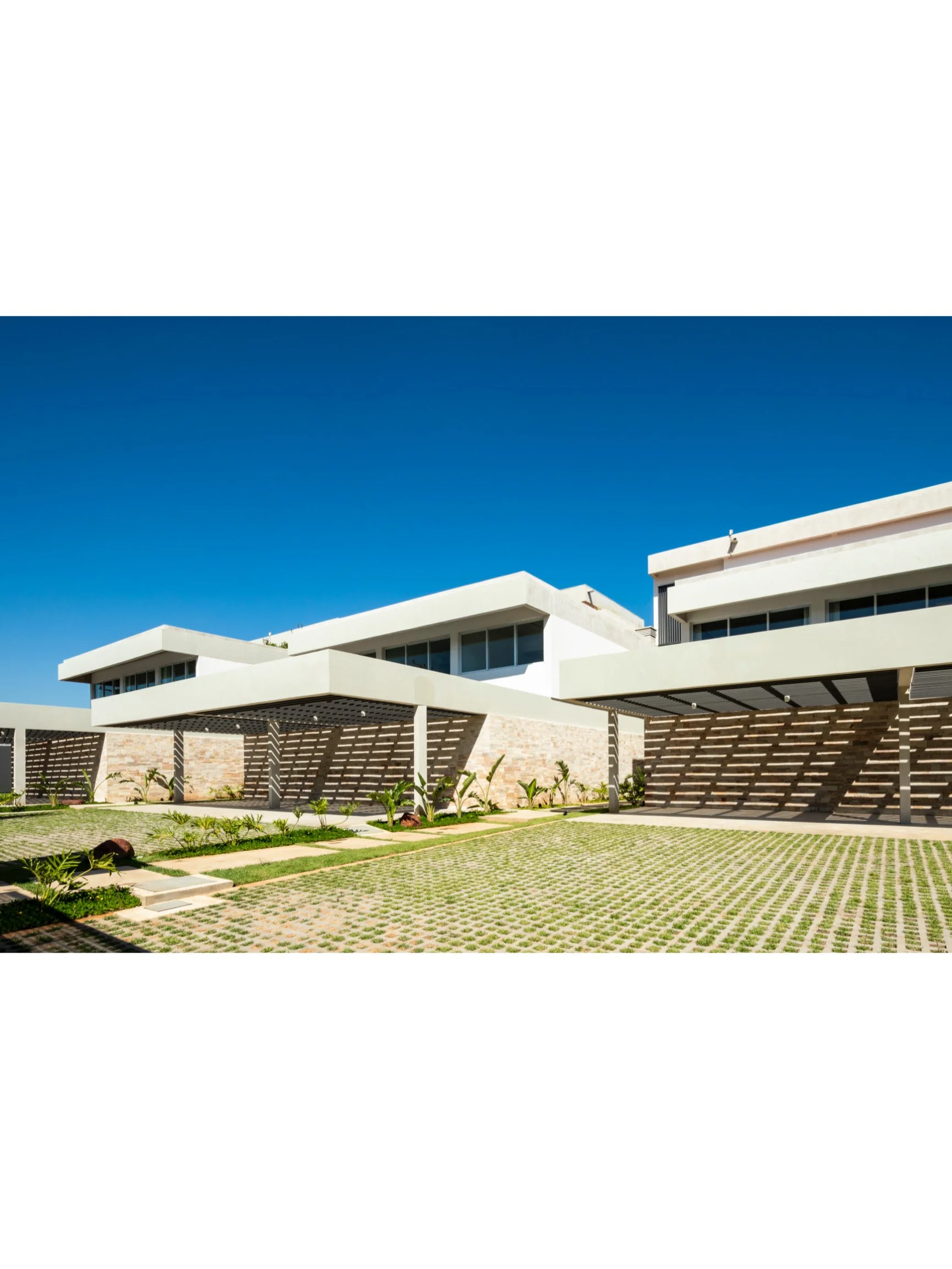 PRO ARQUITECTURA PARAGUAY architecture design PROSA
Residencias modernas con jardines y áreas de estacionamiento bajo un cielo azul brillante.