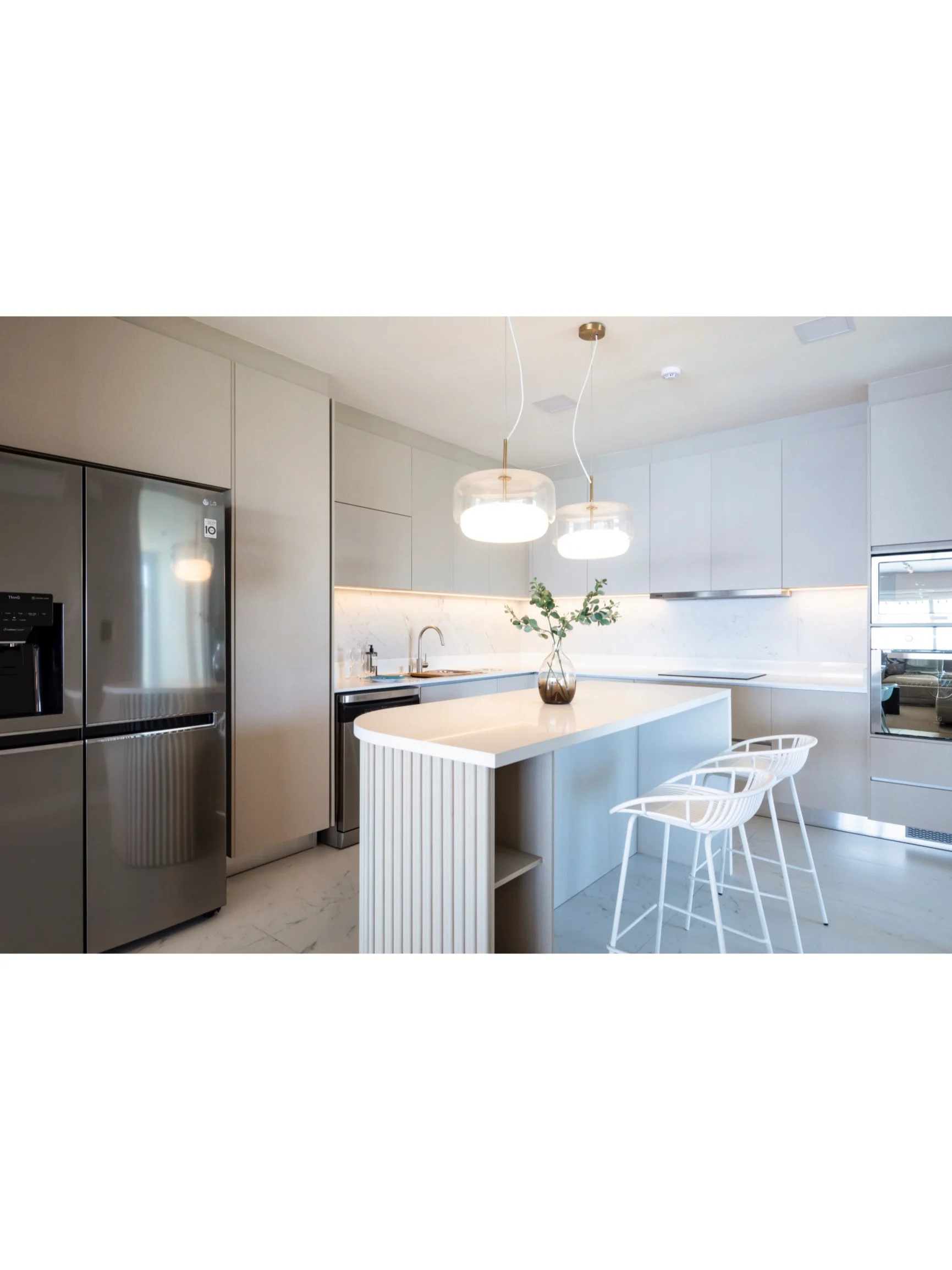 PRO ARQUITECTURA PARAGUAY architecture design PROSA
Cocina moderna con isla central, sillas blancas, electrodomésticos de acero inoxidable y lámparas colgantes.