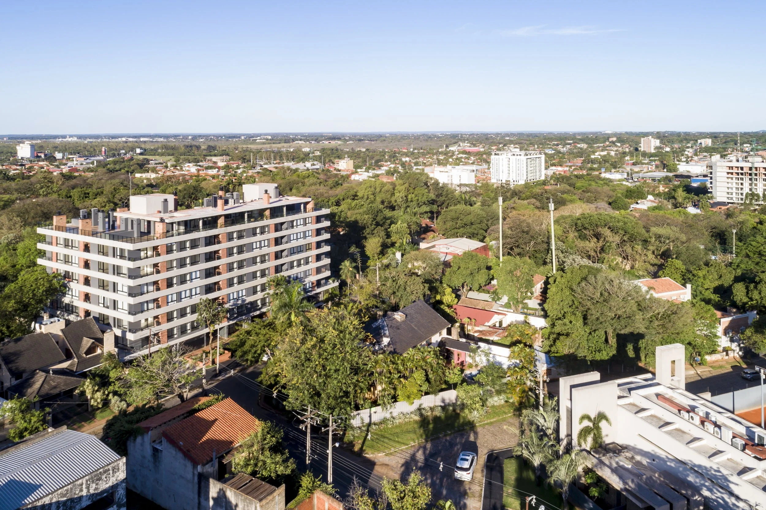 Vista aérea de una ciudad con edificios residenciales y muchas áreas verdes.