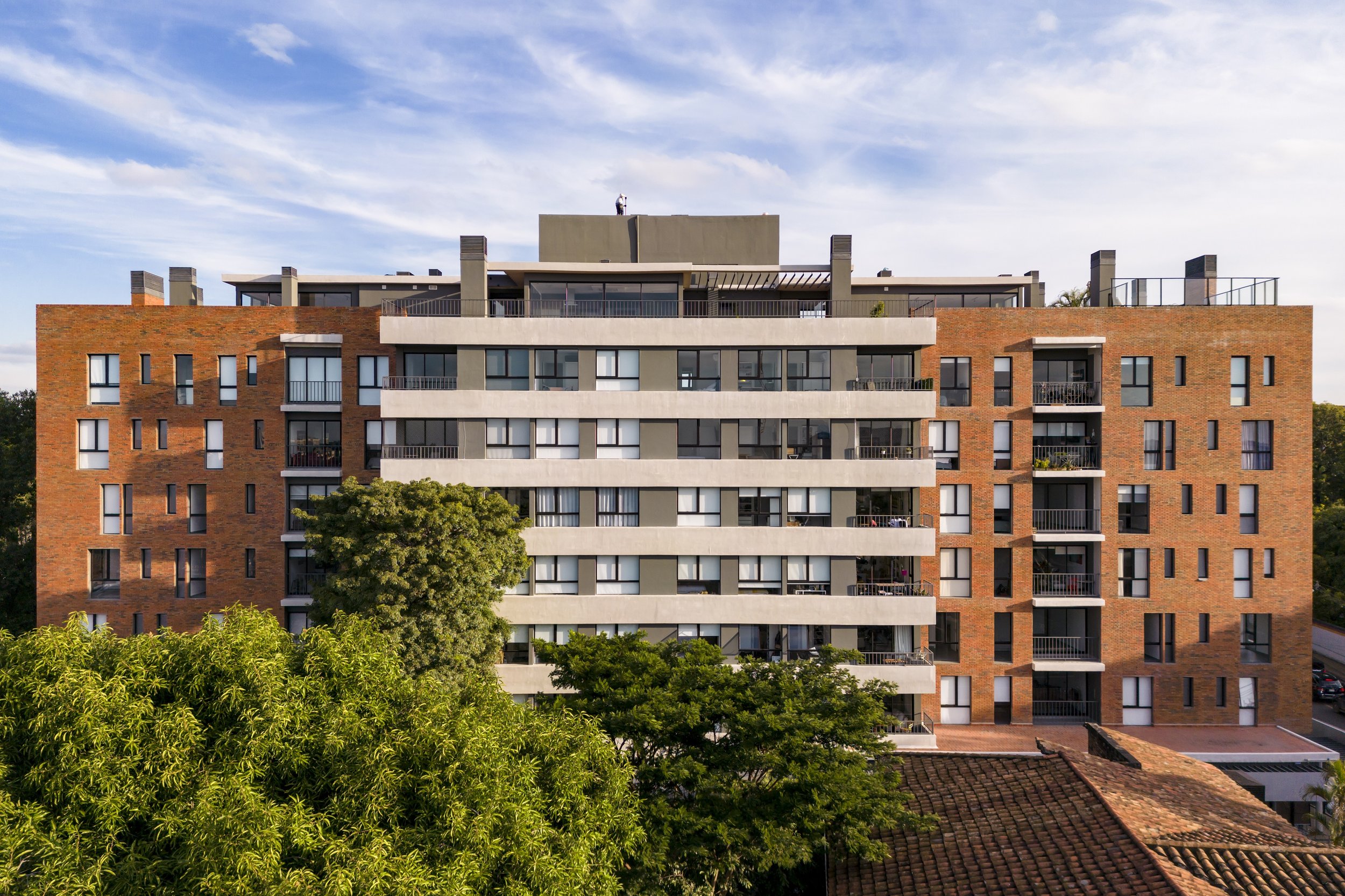 	
PRO ARQUITECTURA PARAGUAY architecture design PROSA
Edificio residencial de varios pisos con balcones y ventanas, rodeado de árboles y con cielo despejado.