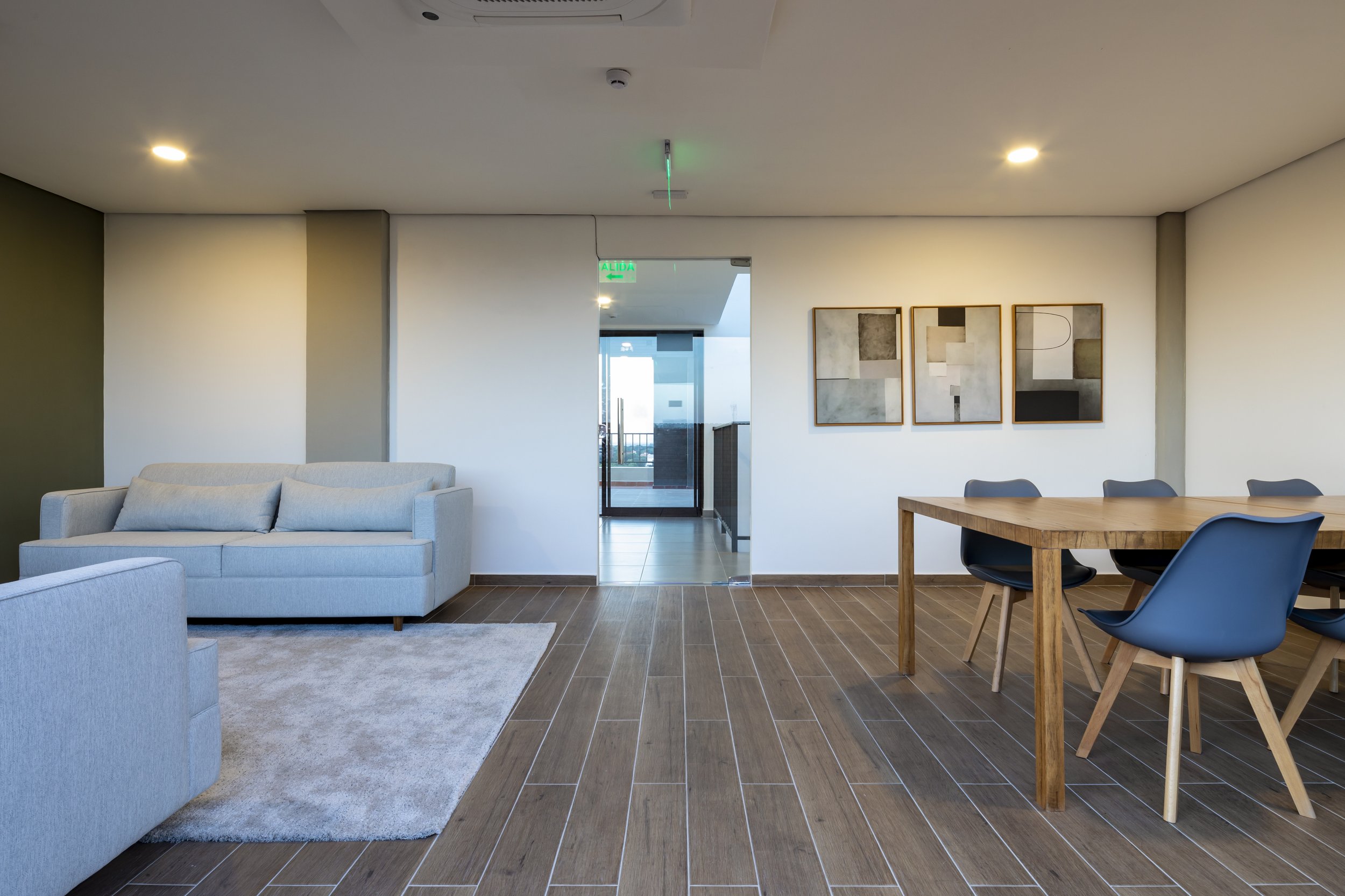 	
PRO ARQUITECTURA PARAGUAY architecture design PROSA
Sala de estar moderna con sillón, sofá y mesa de comedor de madera con cinco sillas negras en un entorno luminoso y espacioso.