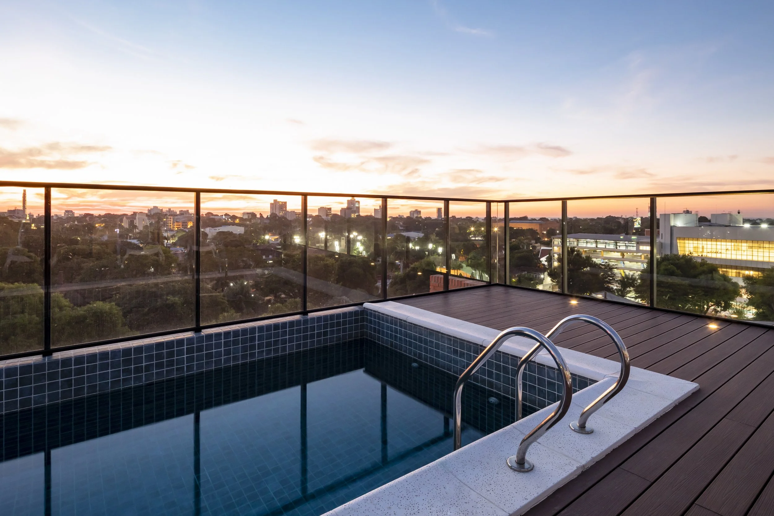 	
PRO ARQUITECTURA PARAGUAY architecture design PROSA
Piscina en la azotea durante el atardecer con vista a la ciudad y cielo nublado