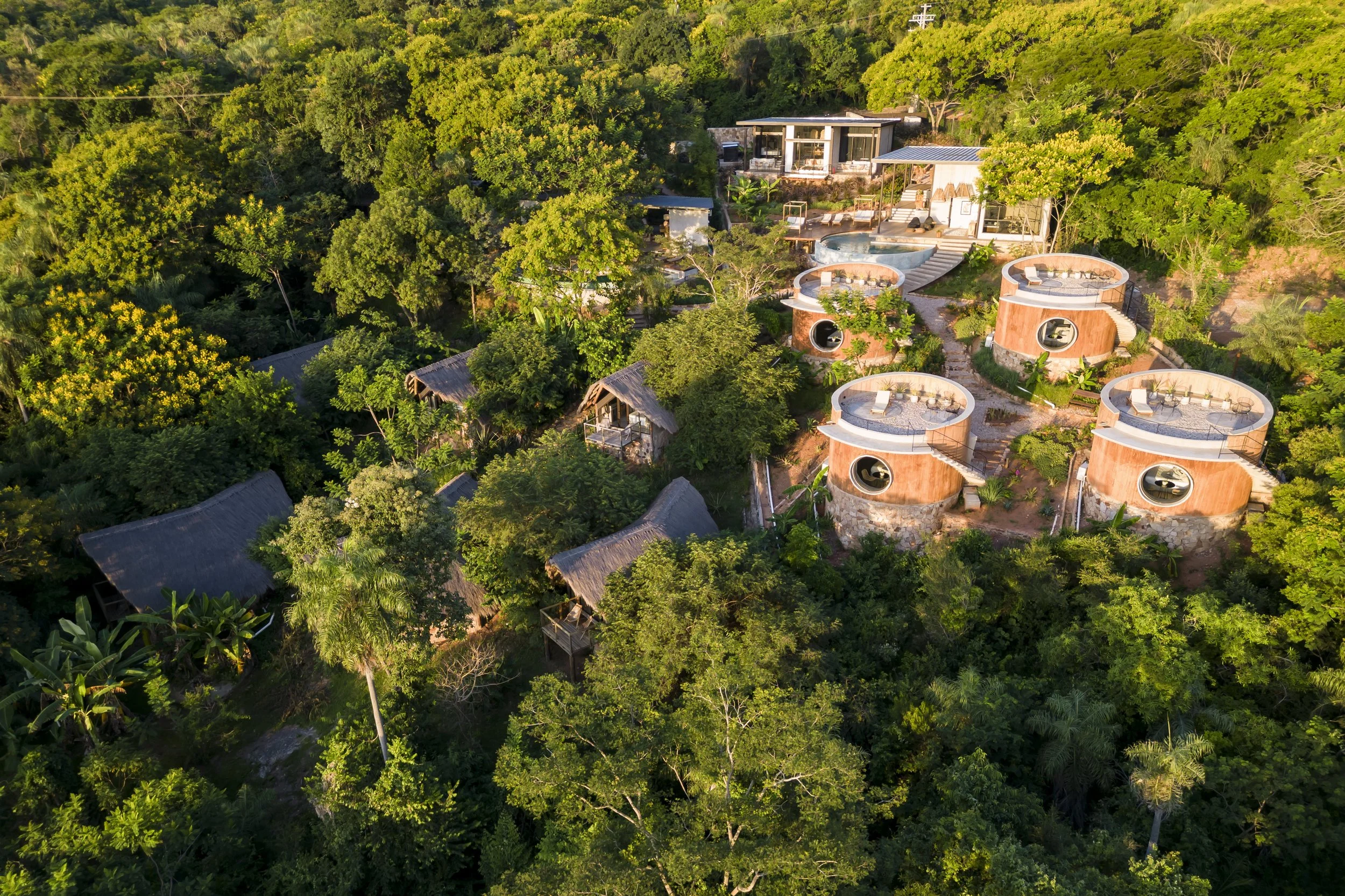 	
PRO ARQUITECTURA PARAGUAY architecture design PROSA
Conjunto de cabañas redondas y modernas en un entorno selvático, con áreas de descanso en terraza y vegetación frondosa.