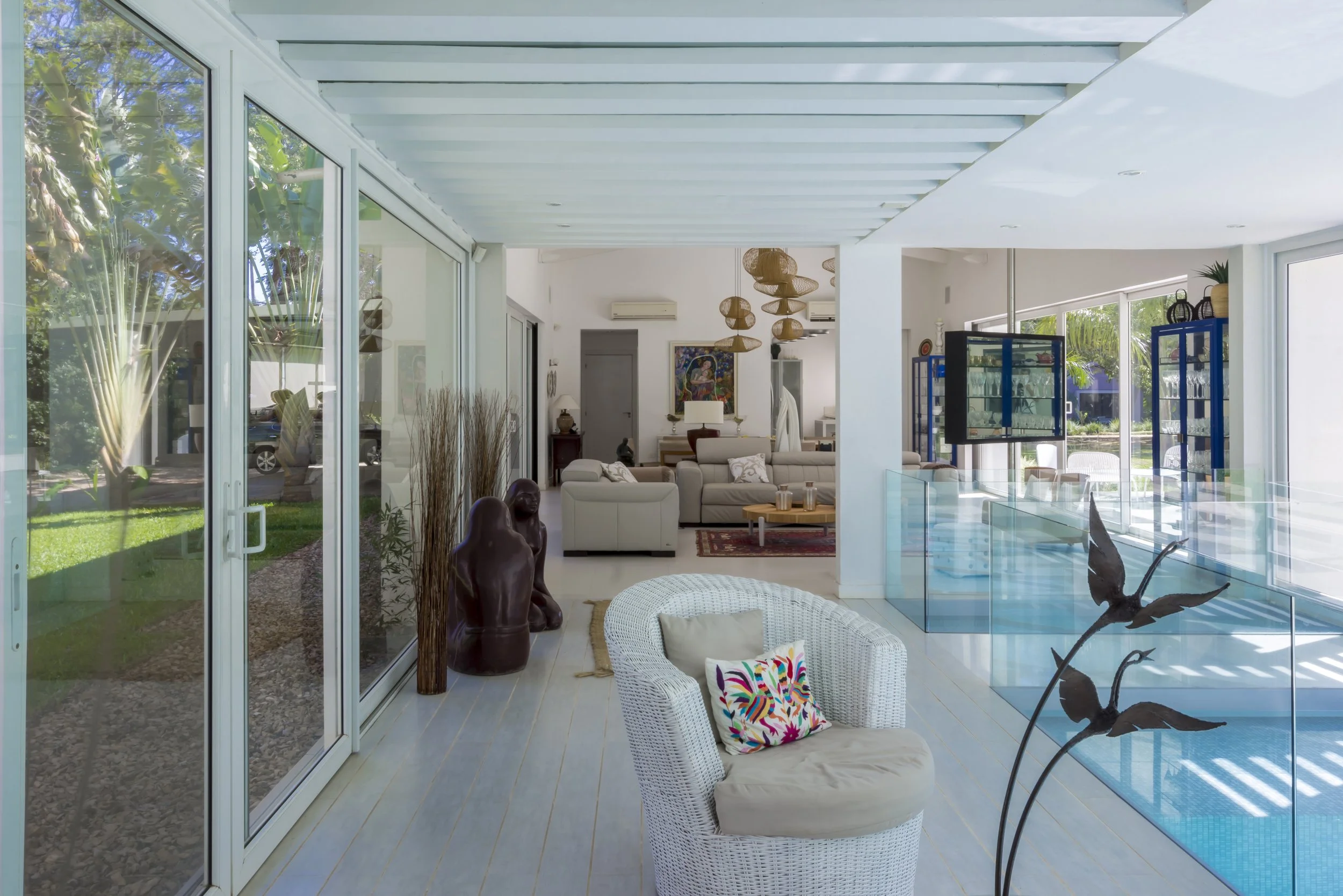 Interior de casa moderna con sala, área de piscina y decoración variada