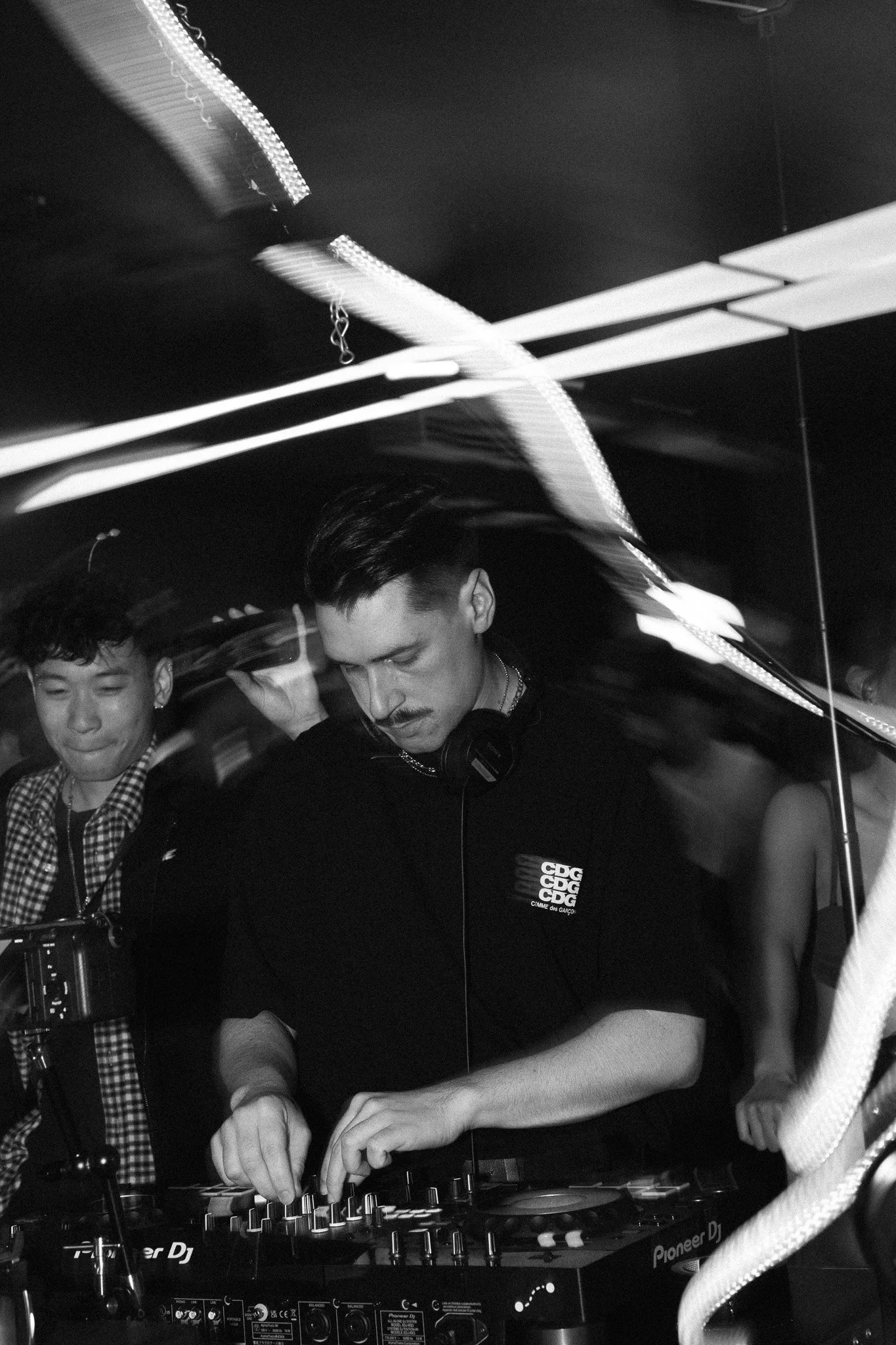 A DJ wearing headphones playing music at a party.