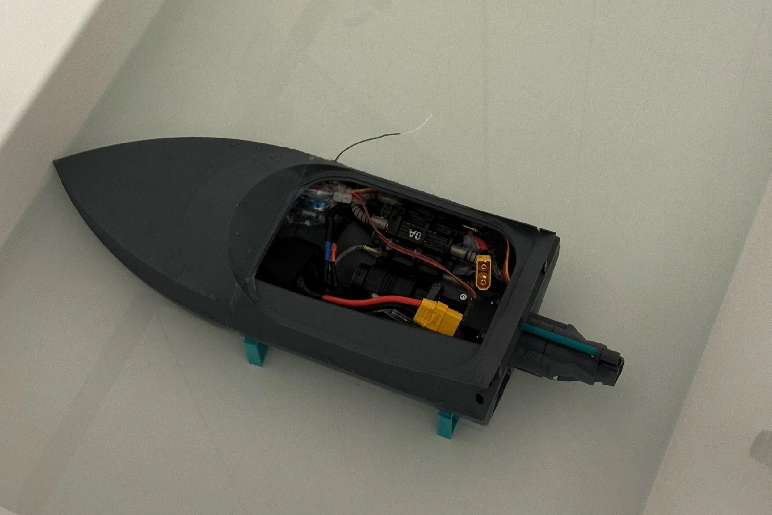 Close-up of a small spaceship model with its top half removed to show internal electronics and wiring.