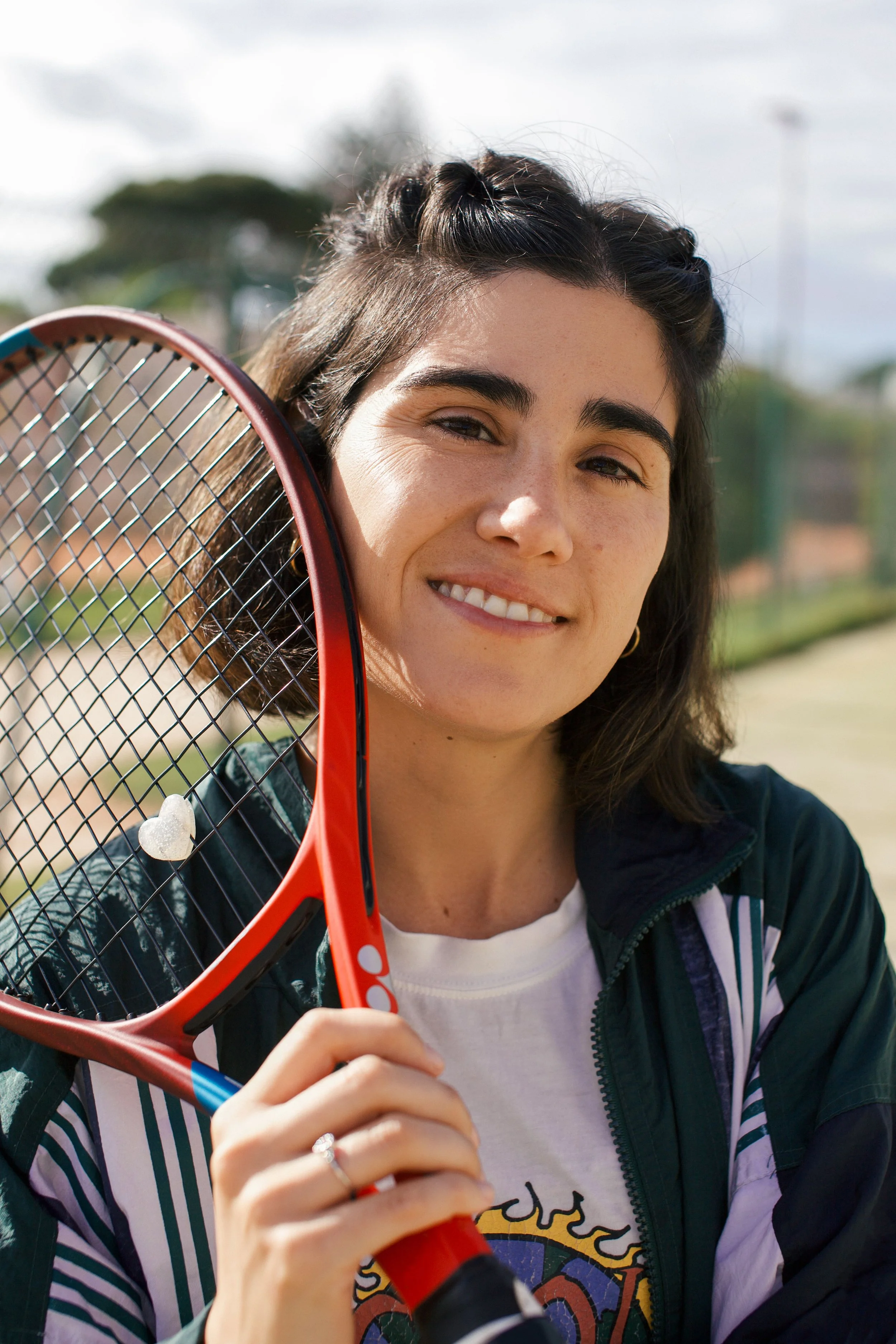 Una joven argentina con una raqueta de tenis en una cancha de tenis en un día soleado