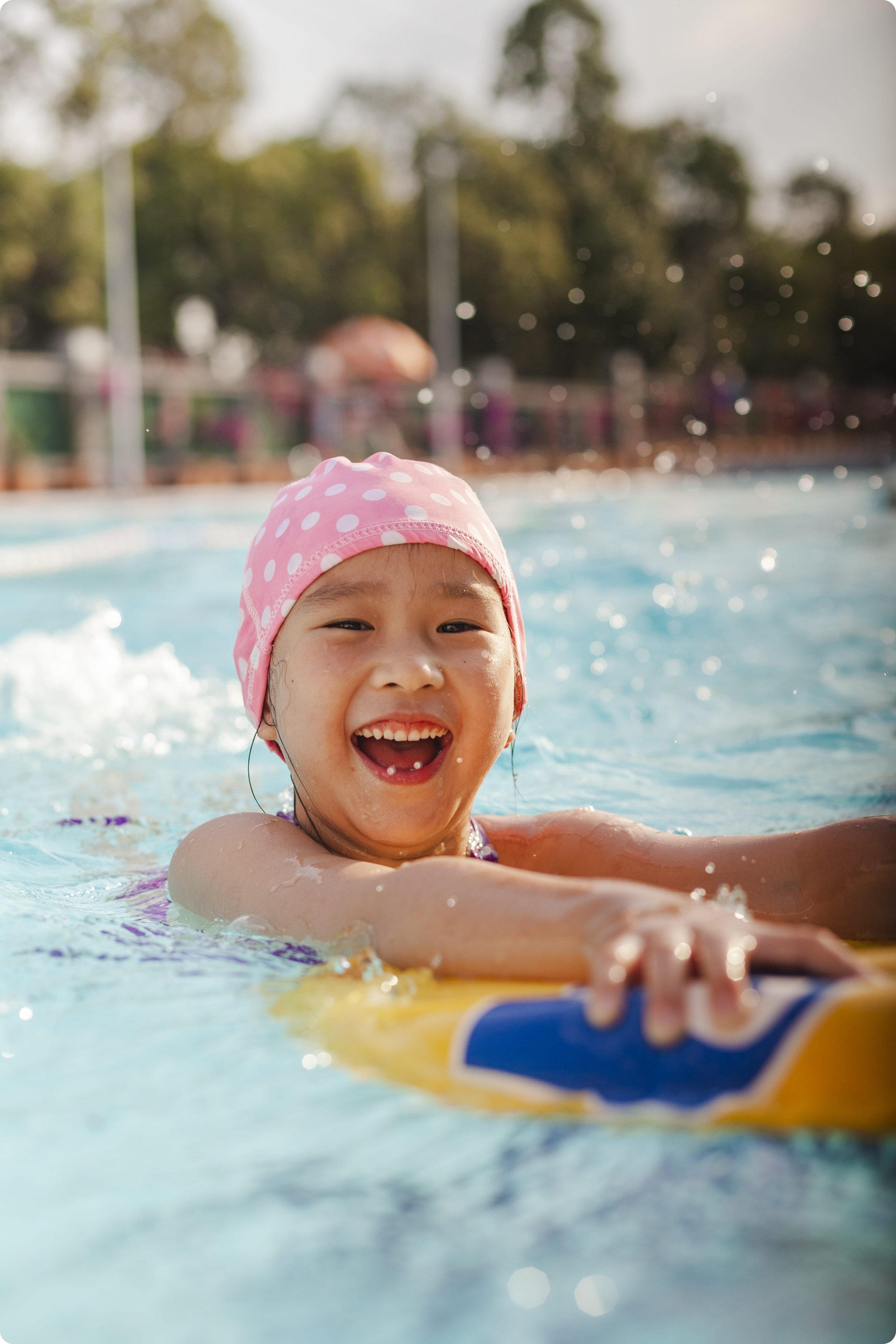 Glückliches asiatisches Mädchen vergnügt sich an einem Sommernachmittag im Pool