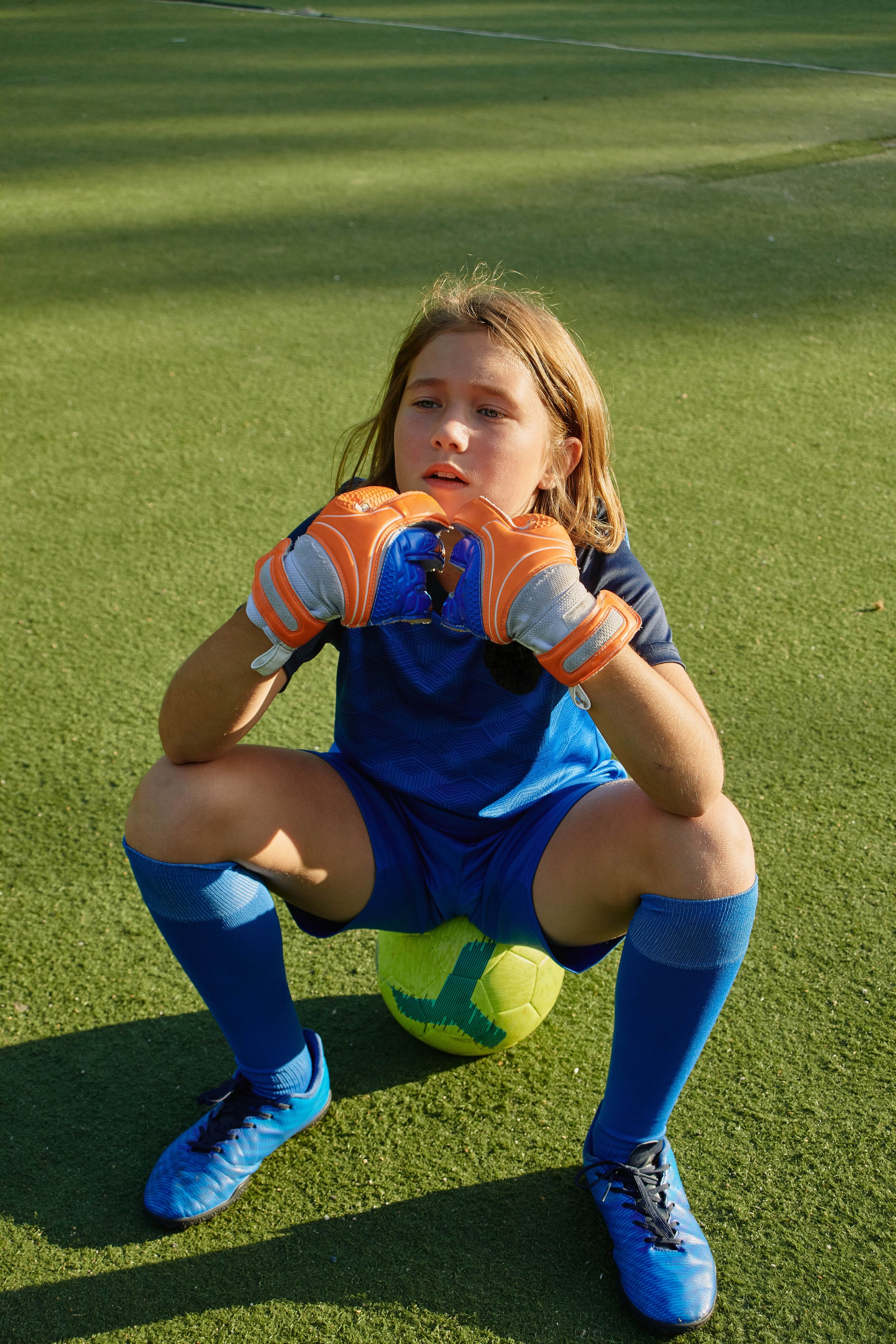 Junger Fußballspieler ruht sich beim Training im Sommer auf einem Ball aus