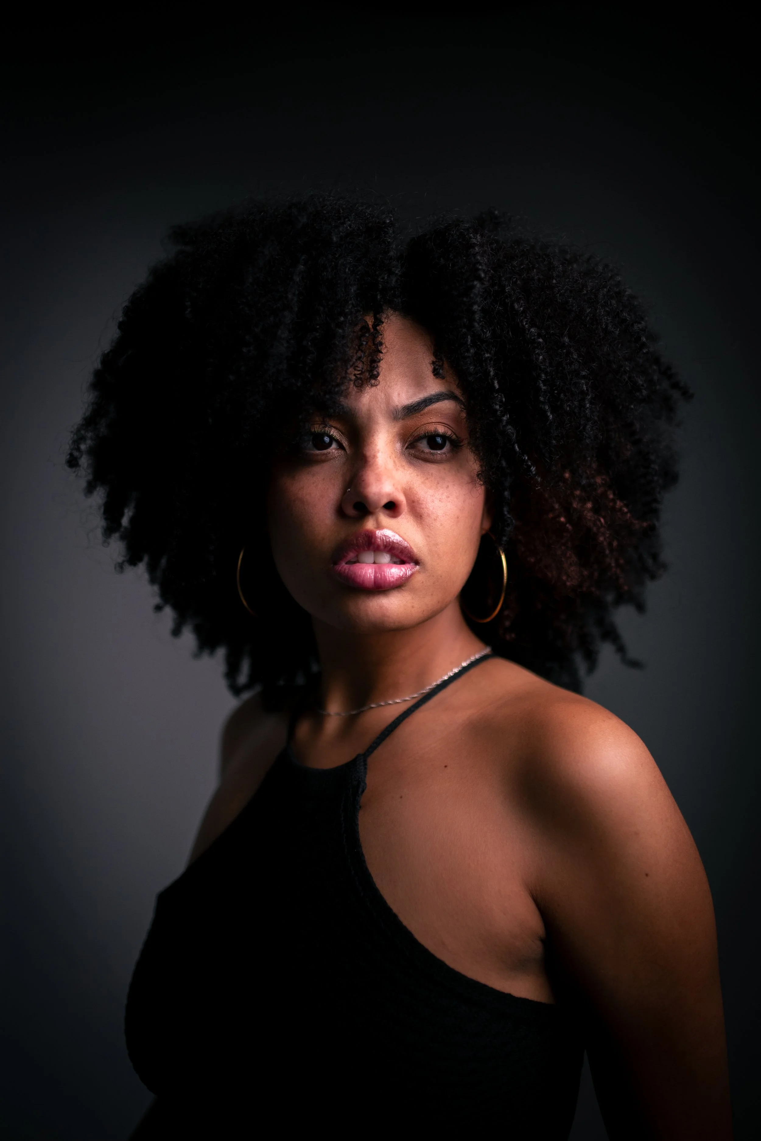 SESSÃO REAL - Mulher negra  com cabelo afro , preto. Usando cropped preto posando .