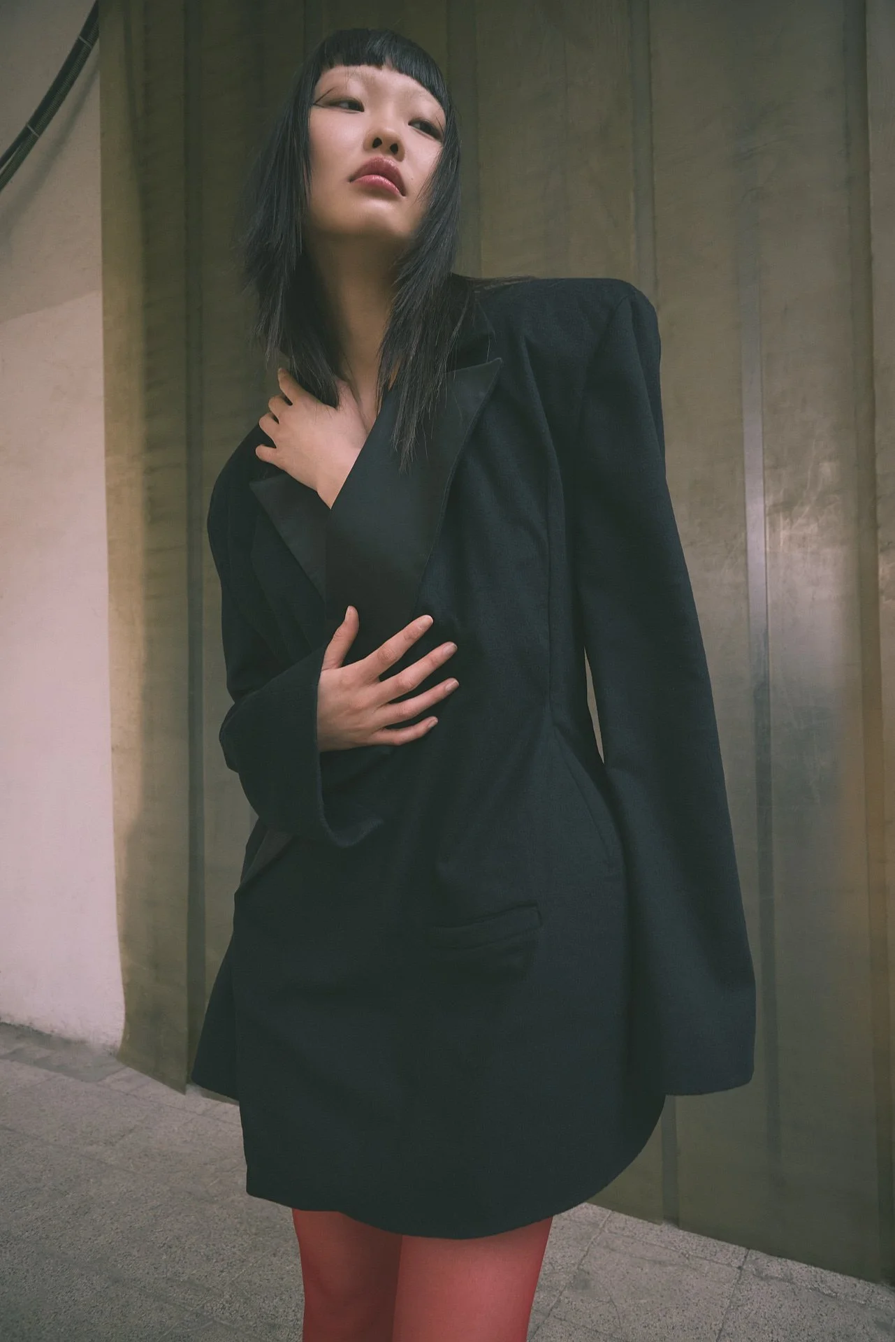 mongolisches model in großem schwarzen blazer in instustriehalle