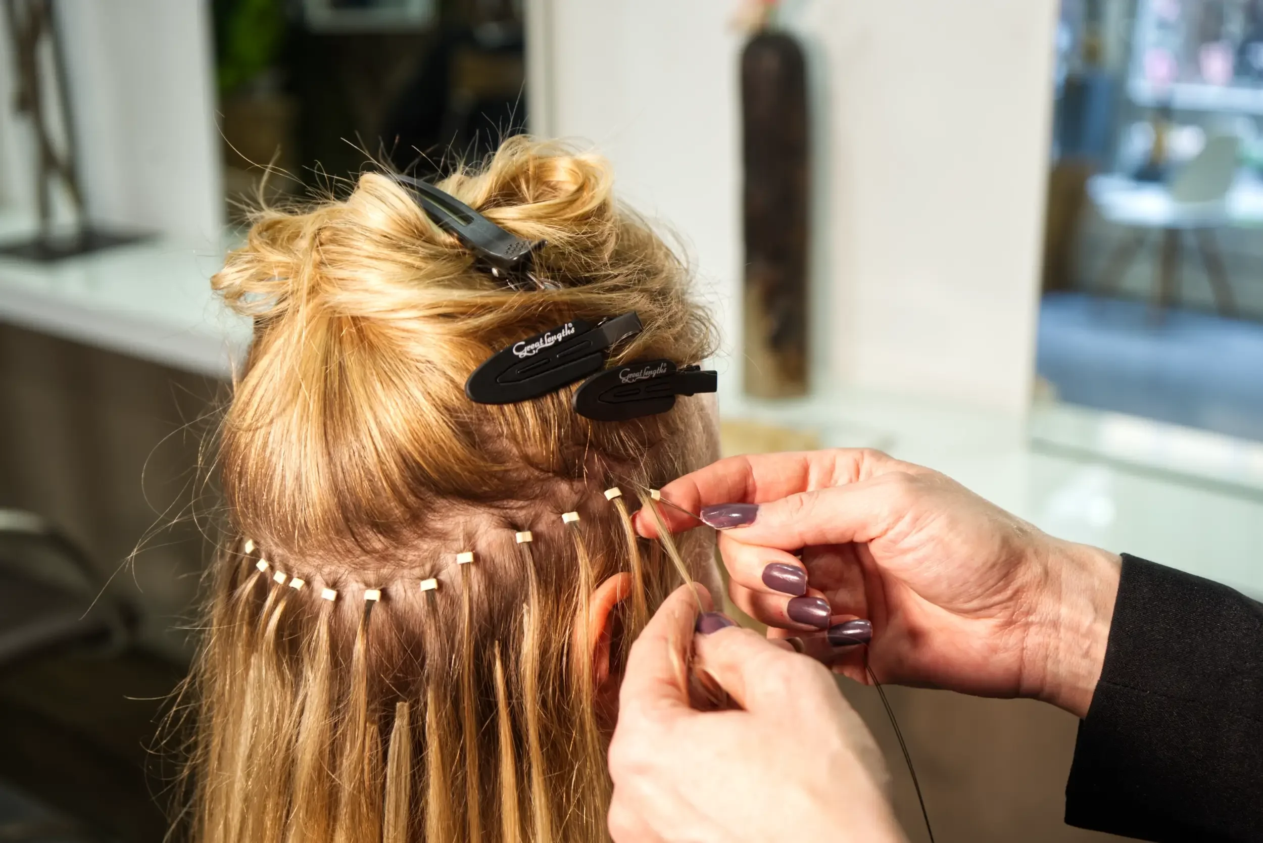 Einarbeitung einer Great Lengths Haarverlängerung mit einzelnen Echthaarsträhnen. Die Extensions werden präzise am Eigenhaar befestigt, um eine natürliche Haarverlängerung mit nahtlosen Übergängen bei Garzareck Halle (Saale) zu erzielen.