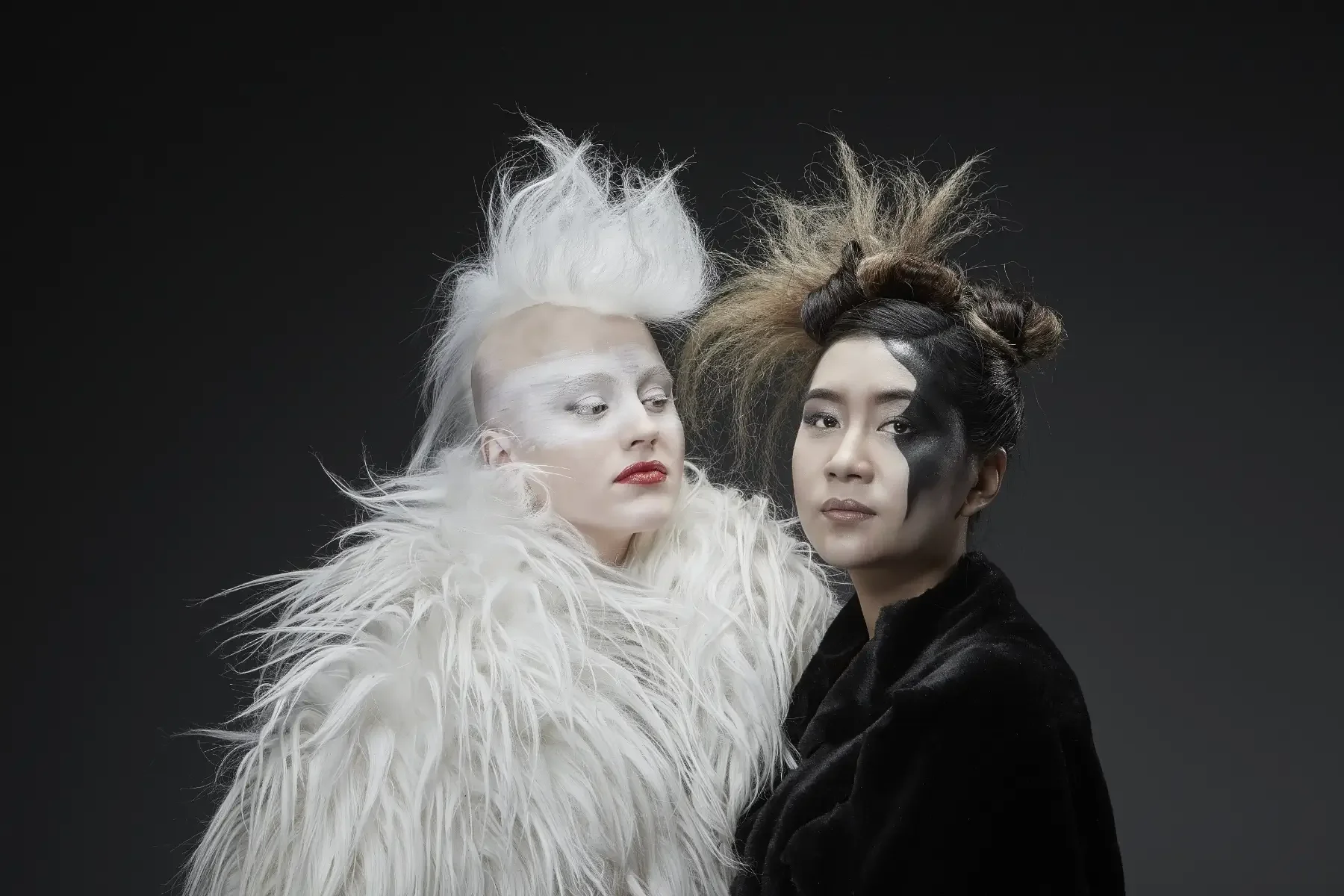 Avantgardistisches Duo-Porträt aus der Black-&-White-Fotoaktion mit kontrastierendem Weiß- und Schwarz-Styling, skulpturalem Haar, grafischem Make-up und ruhiger, gemeinsamer Präsenz vor dunklem Hintergrund bei Garzareck in Halle (Saale).