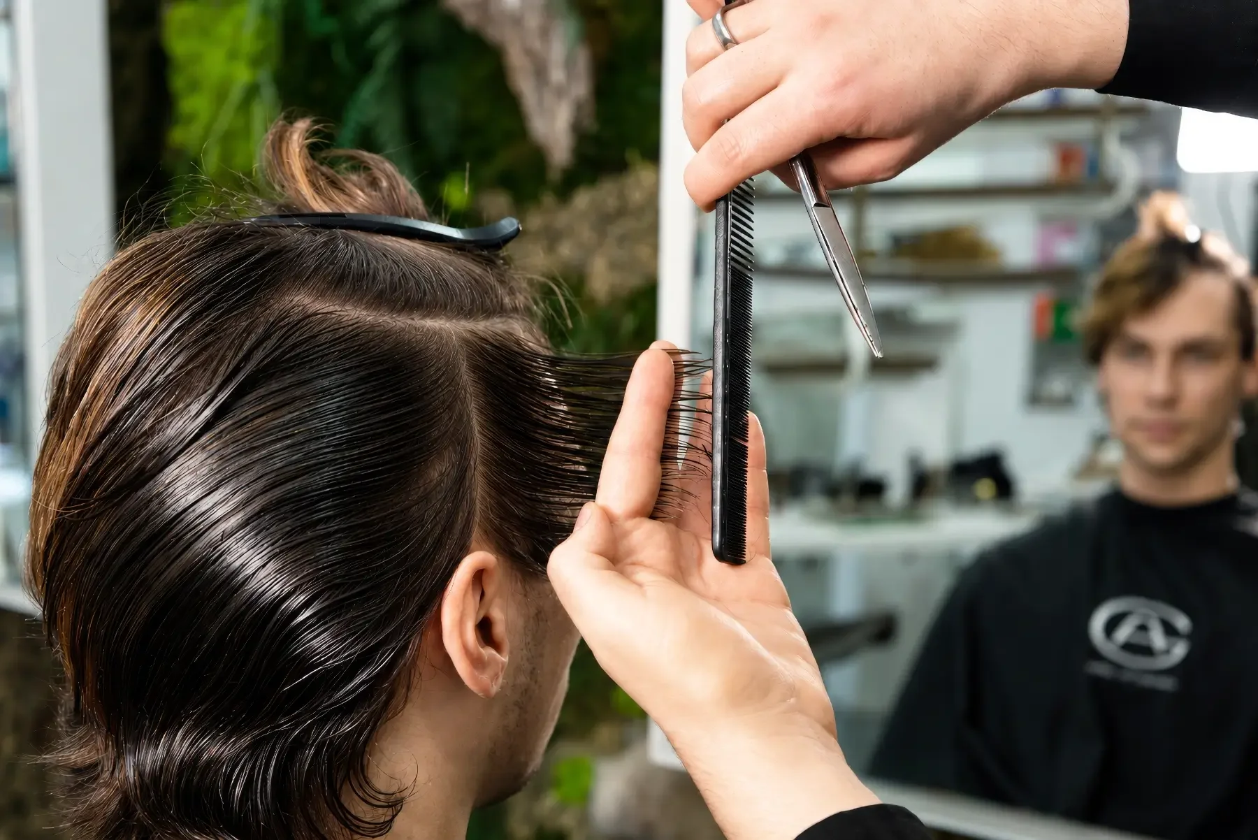 Friseur schneidet die Haare eines Kunden präzise nach individueller Haarstruktur und Gesichtsform. Herrenhaarschnitt und persönliche Stilberatung bei Garzareck Coiffeur & Cosmetics in Halle (Saale).